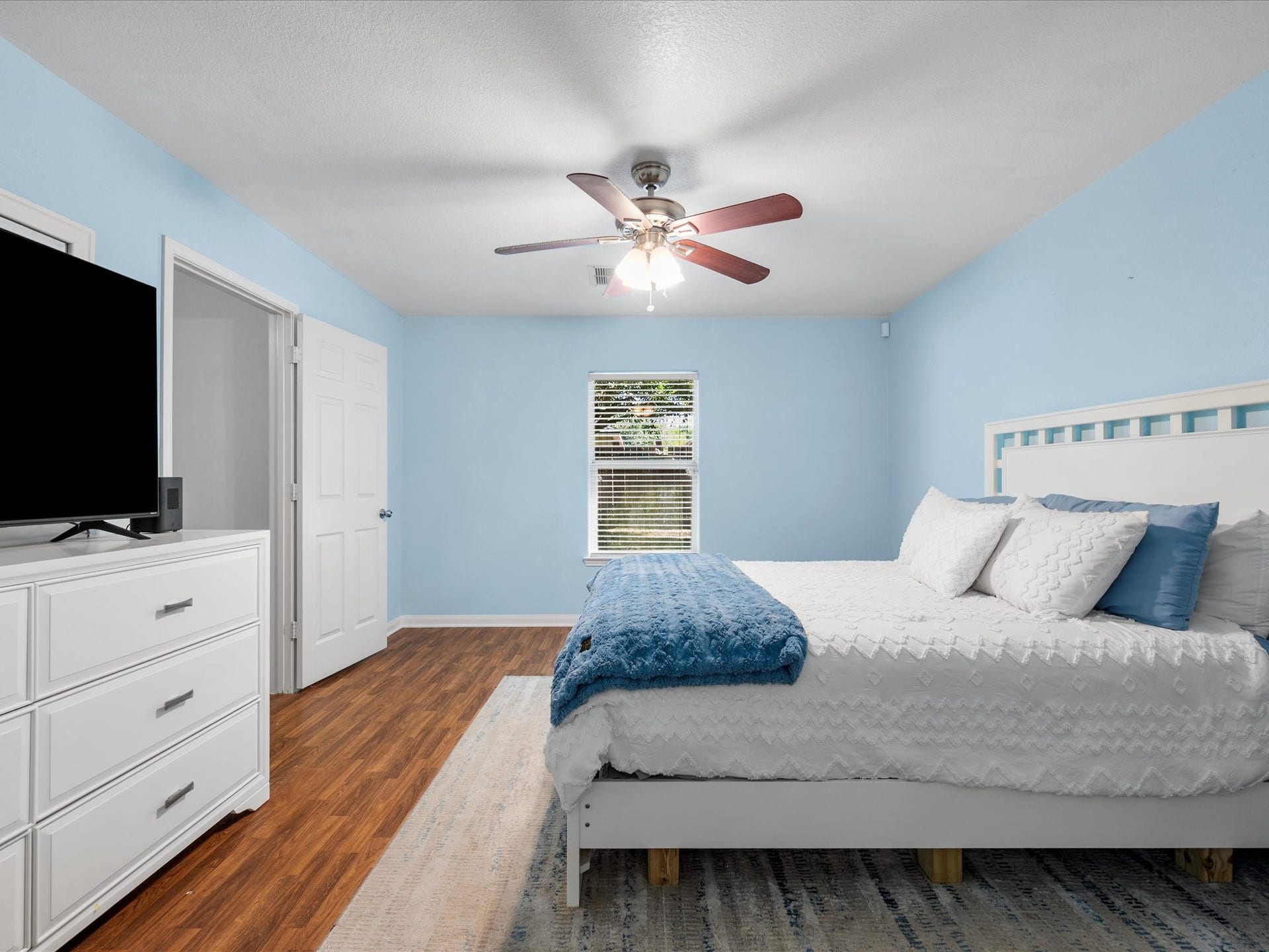 305 Pine Mist Lane, Conroe, TX 77304 Another view of the primary bedroom featuring soft blue walls and wood look flooring.