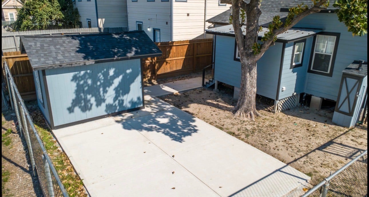 Backyard includes a patio and storage shed