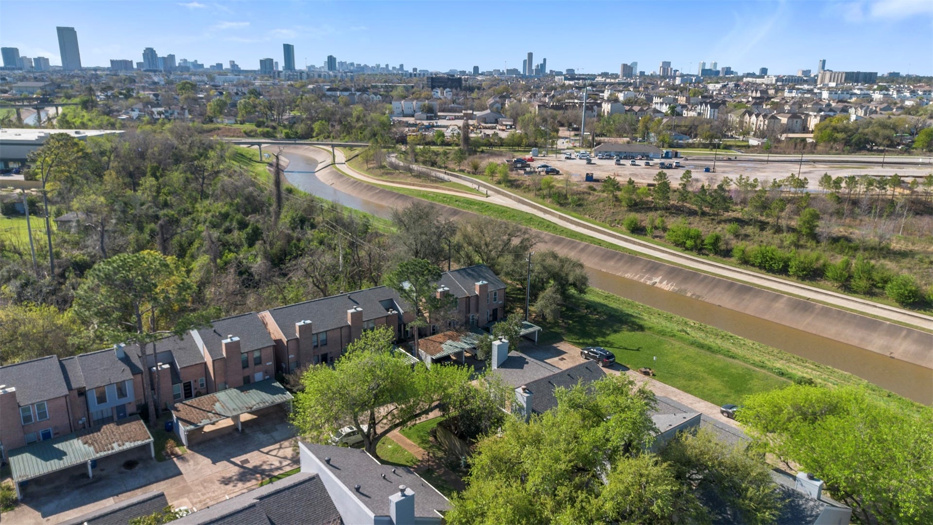 Sweeping aerial view of the surrounding community with the city skyline in the distance.