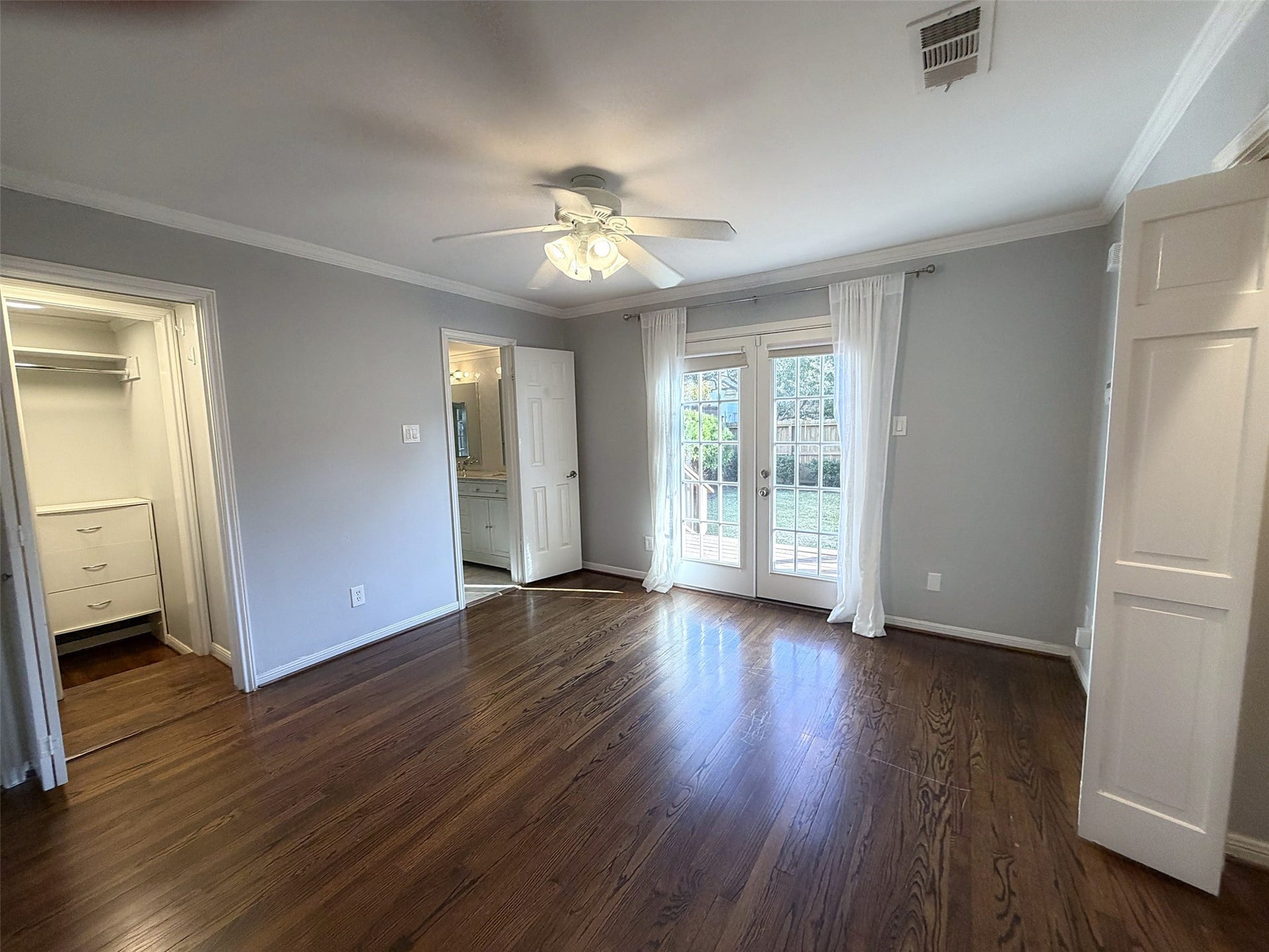Primary Bedroom: Spacious bedroom featuring hardwood floors, neutral colors, and attractive natural lighting.