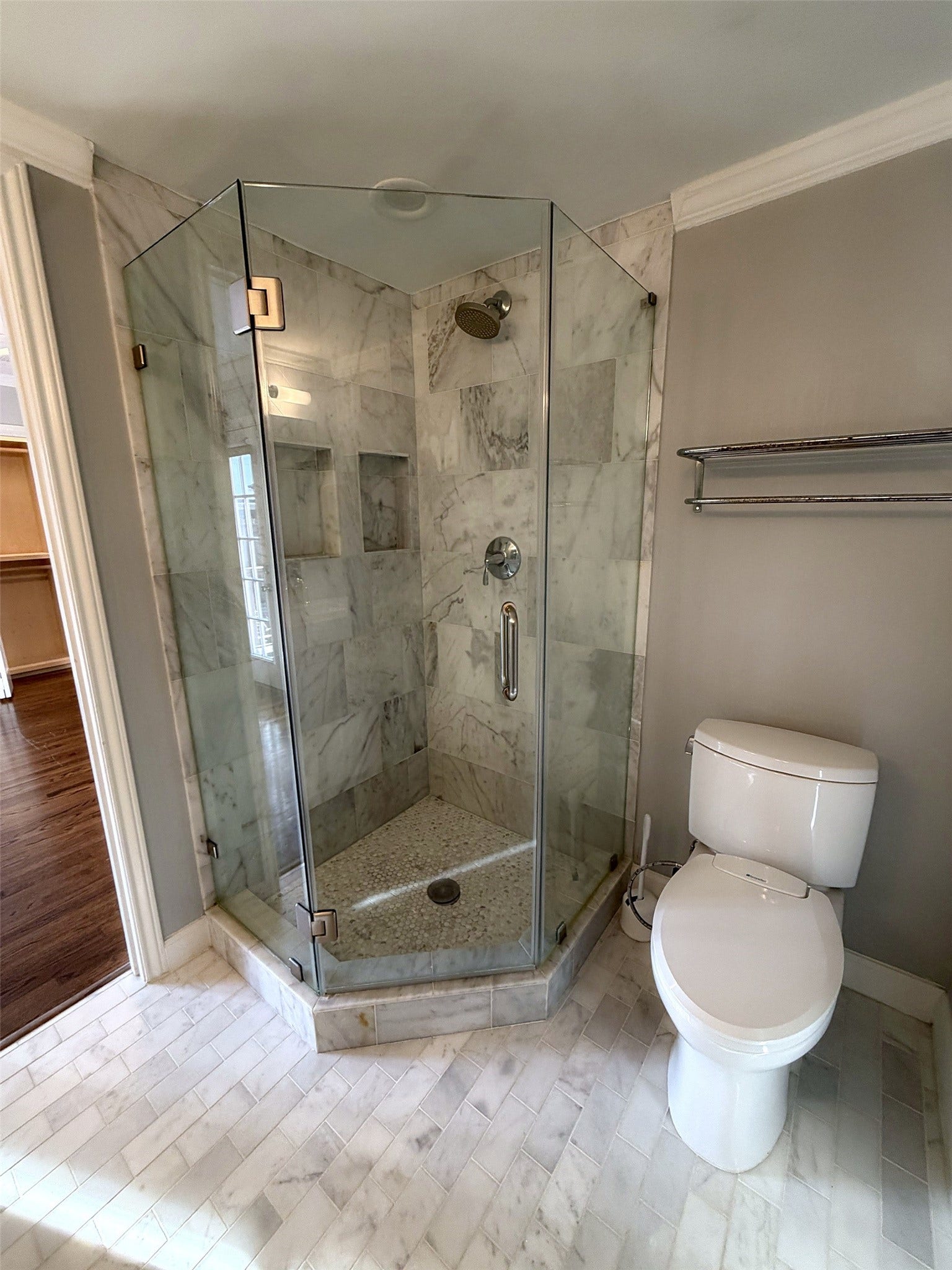 Another view of the primary bathroom with shower and toilet.