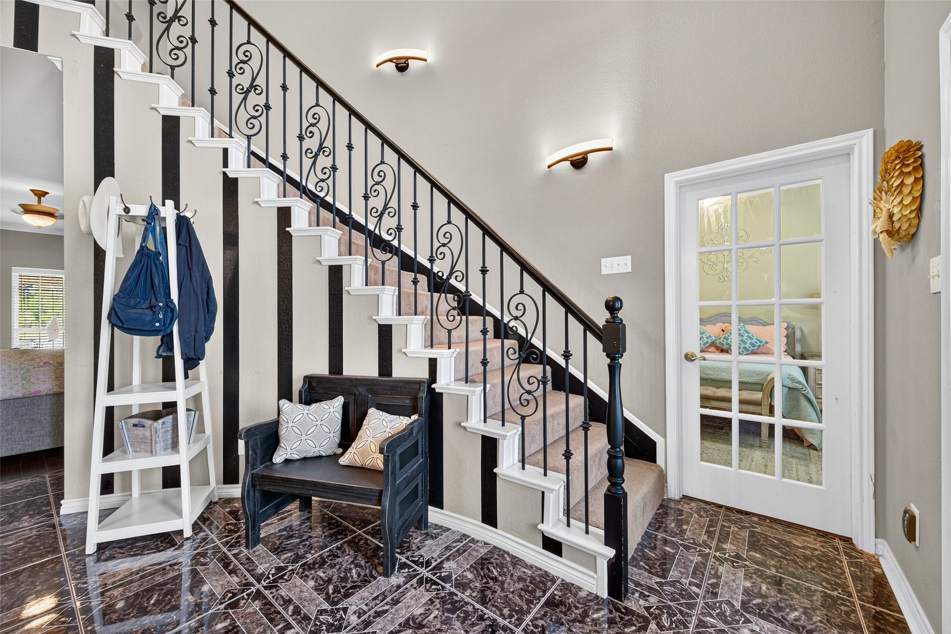 Grand entryway with staircase with decorative iron balusters and tile flooring