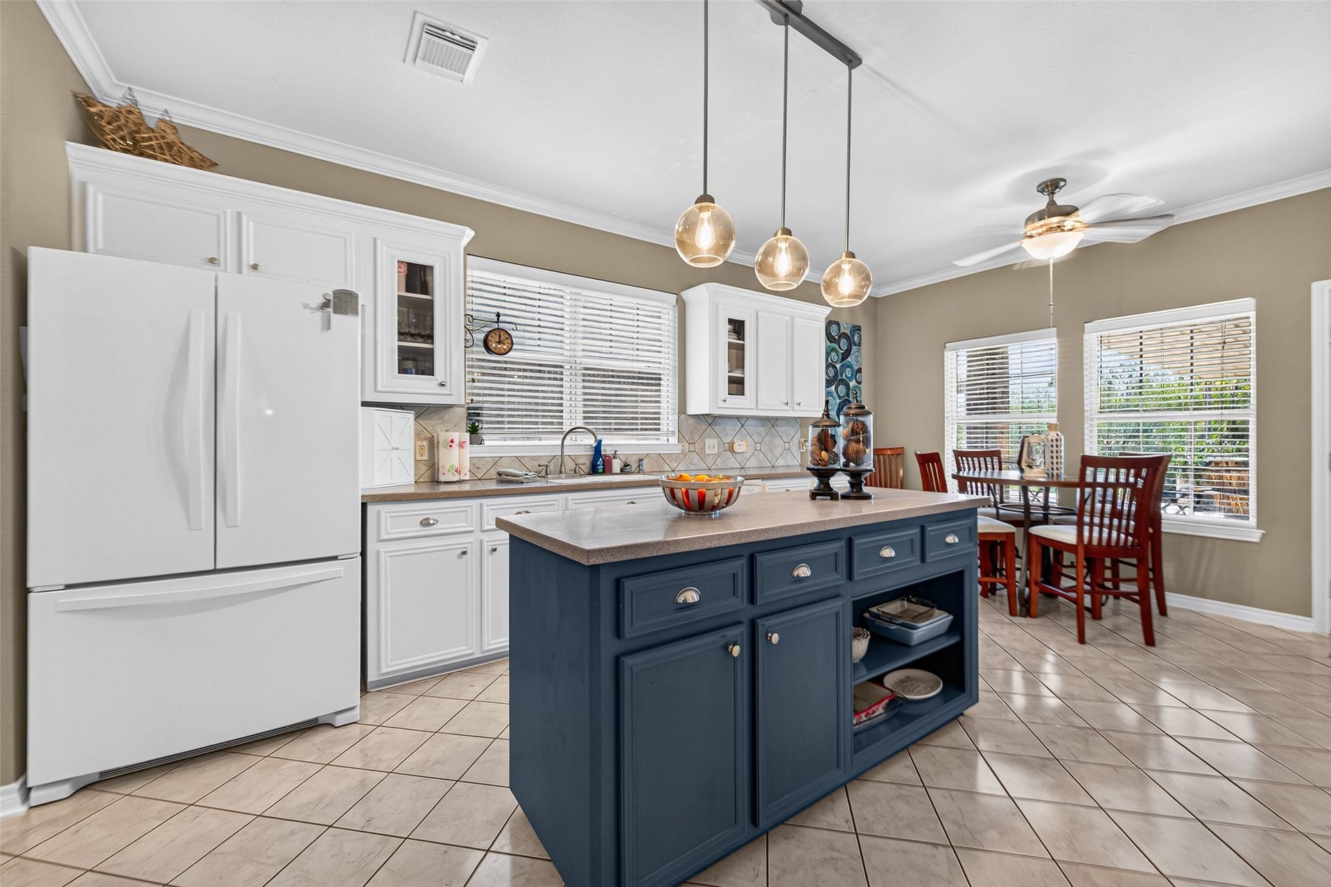 Bright kitchen with white cabinetry, generous counter space, and a contrasting navy island