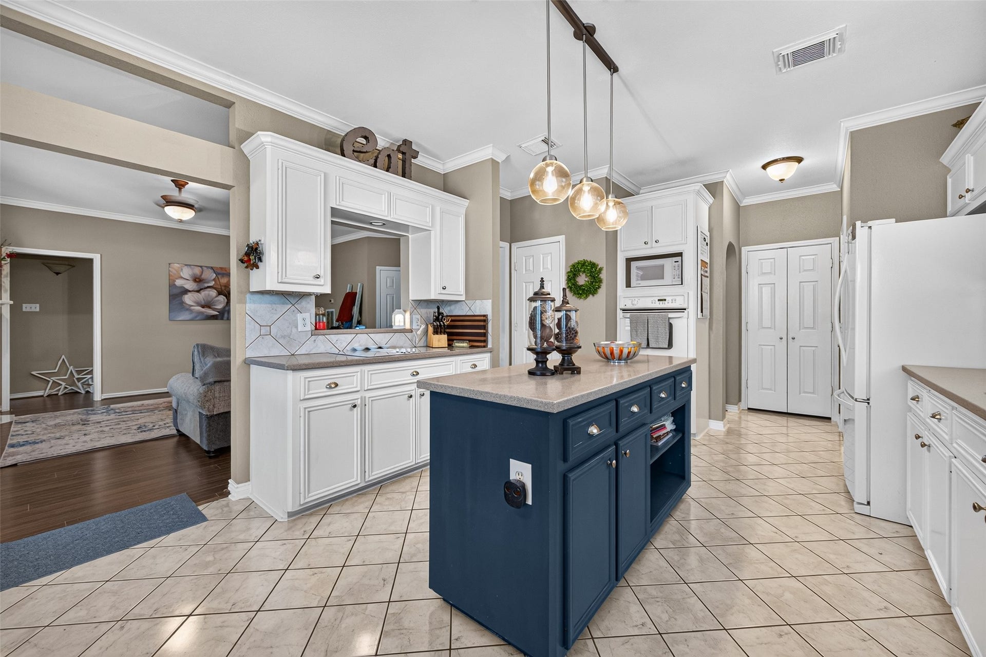 Detailed view of the kitchen's white cabinetry, decorative backsplash tile and ample counter space