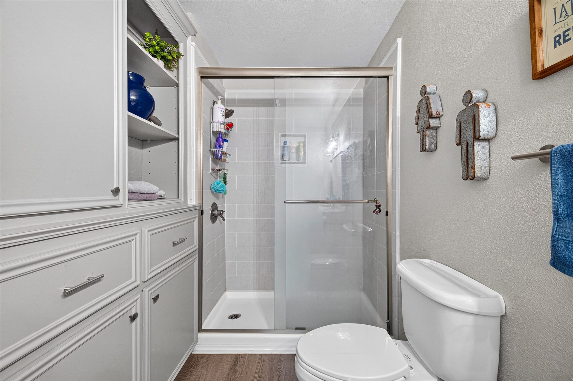 Upstairs bathroom has been renovated and features a glass enclosed shower, white cabinetry, and a clean, neutral finish