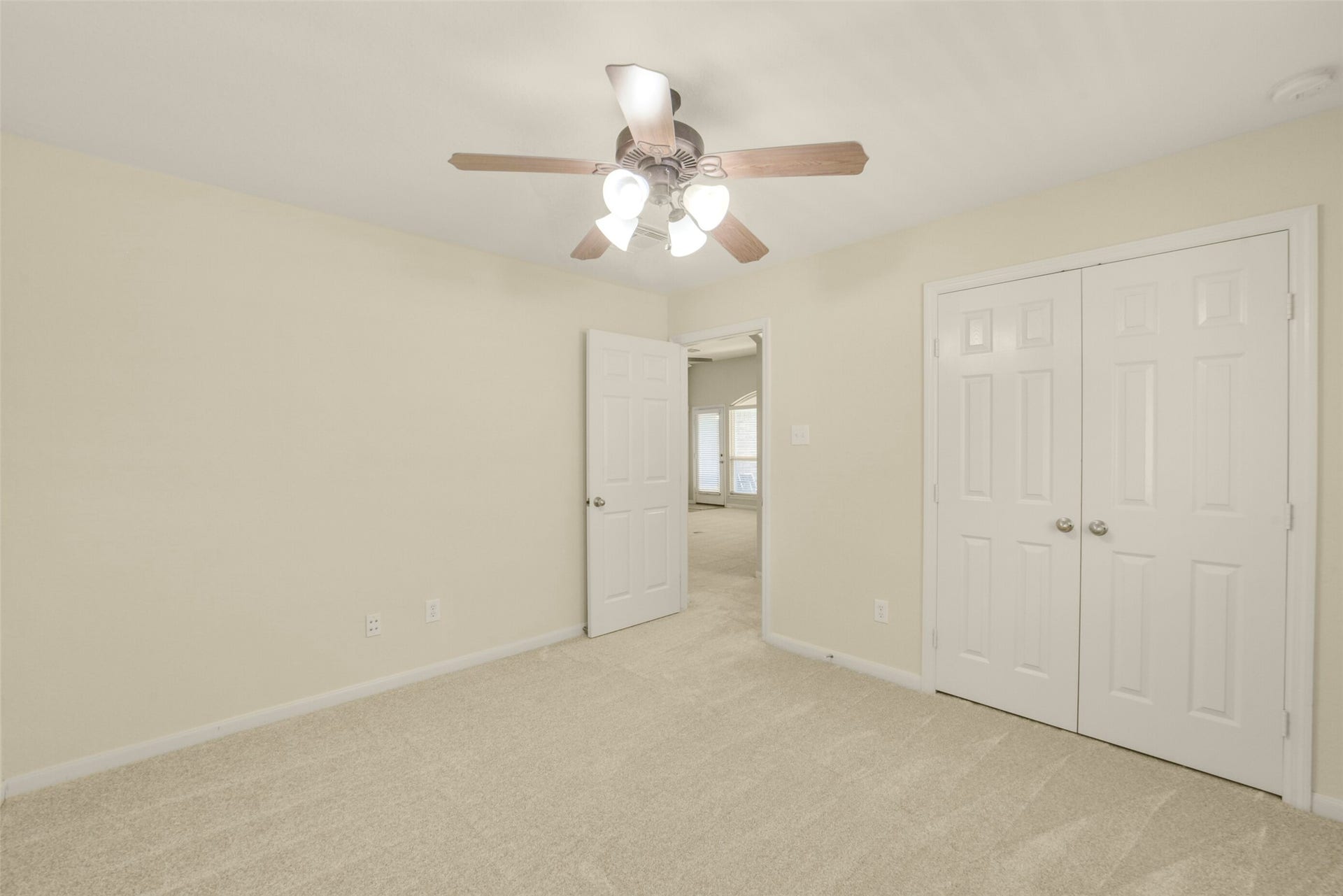 Secondary bedroom with a ceiling fan and dual closets, offering ample storage and comfort.