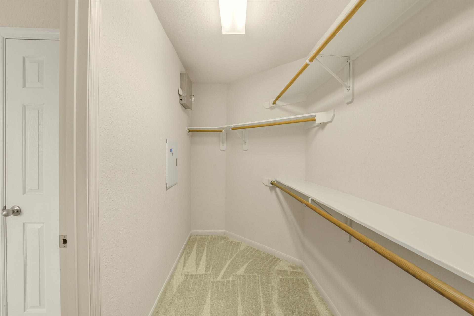 Spacious primary walk-in closet with ample shelving and hanging space, perfect for organizing your wardrobe.