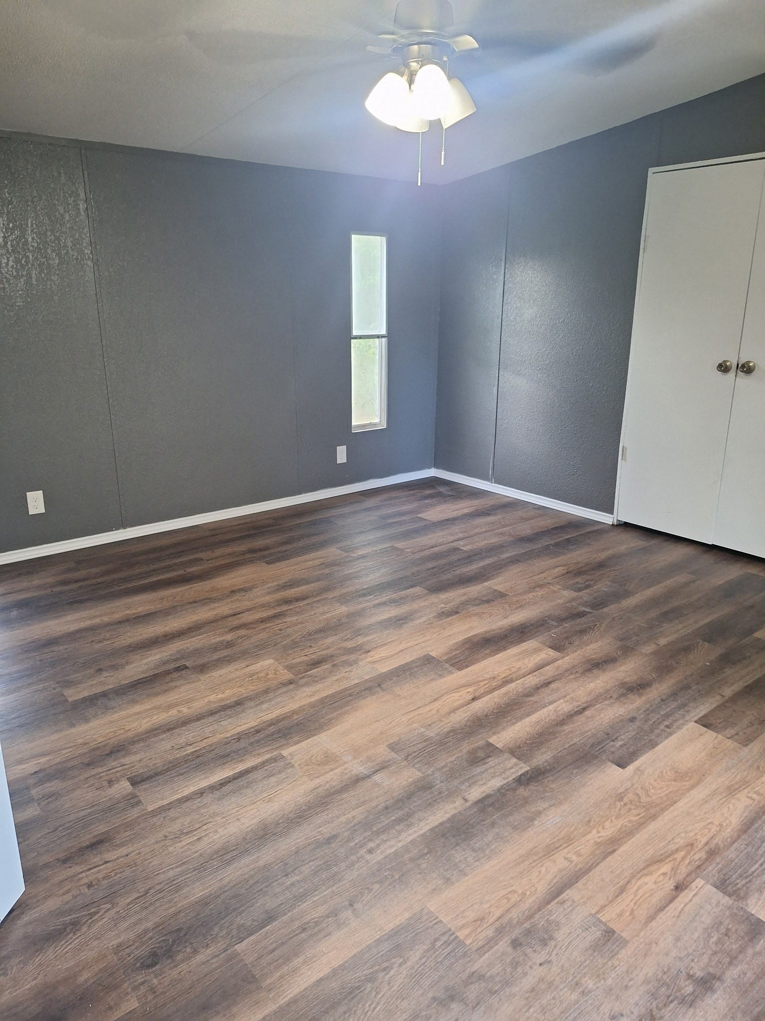 1308 County Road 159, Alvin, TX 77511 Spacious living area with attractive wood-look flooring, neutral paint, and natural lighting.