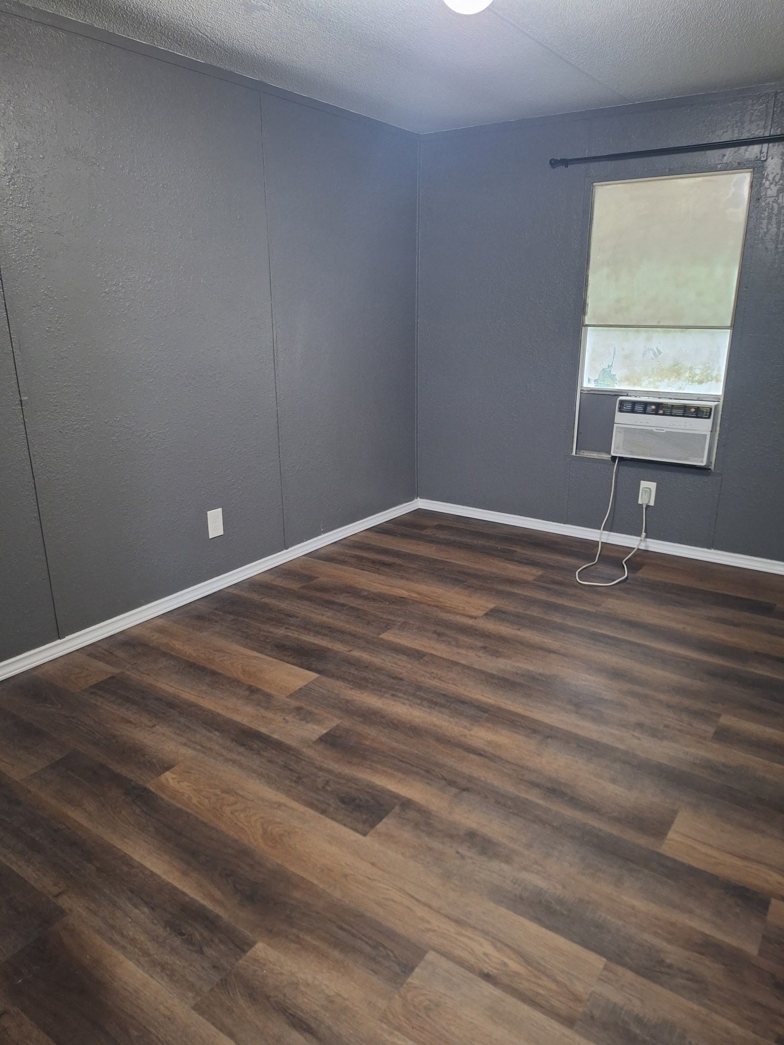 1308 County Road 159, Alvin, TX 77511 Comfortable bedroom with wood-look flooring, neutral paint, and natural light.
