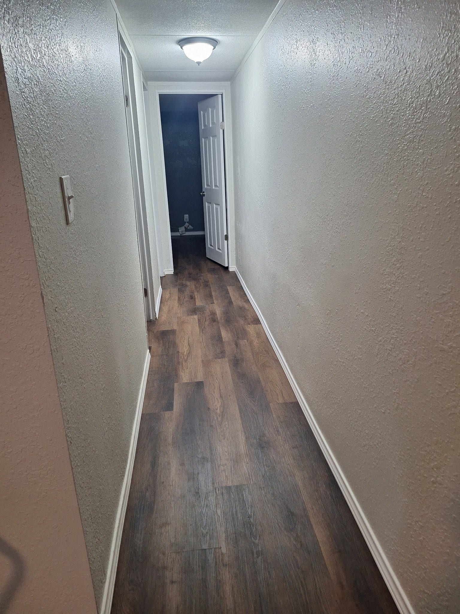 1308 County Road 159, Alvin, TX 77511 Interior hallway featuring updated wood-look flooring and neutral finishes throughout.