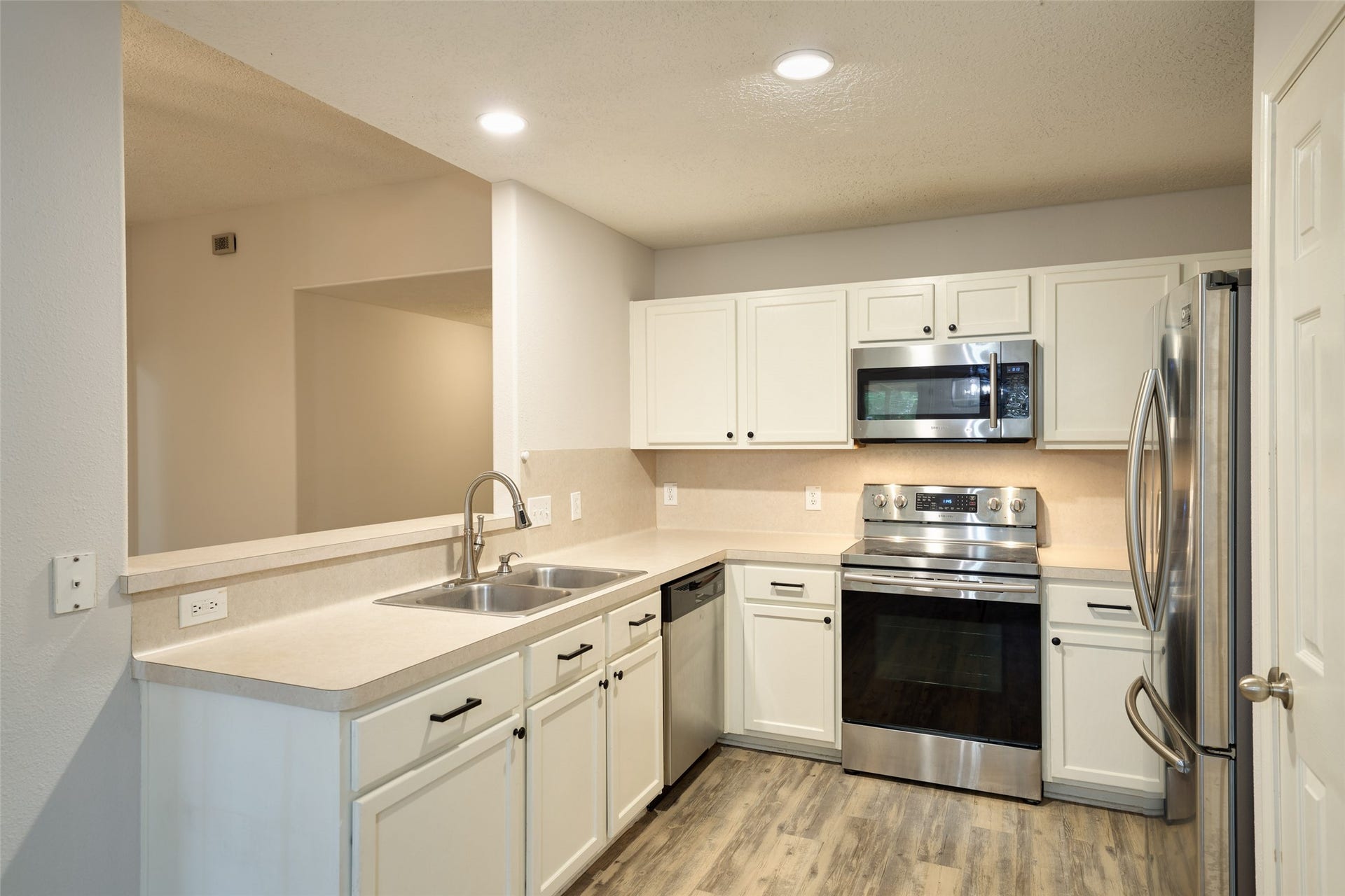 View of kitchen with bar overlooking into living room.