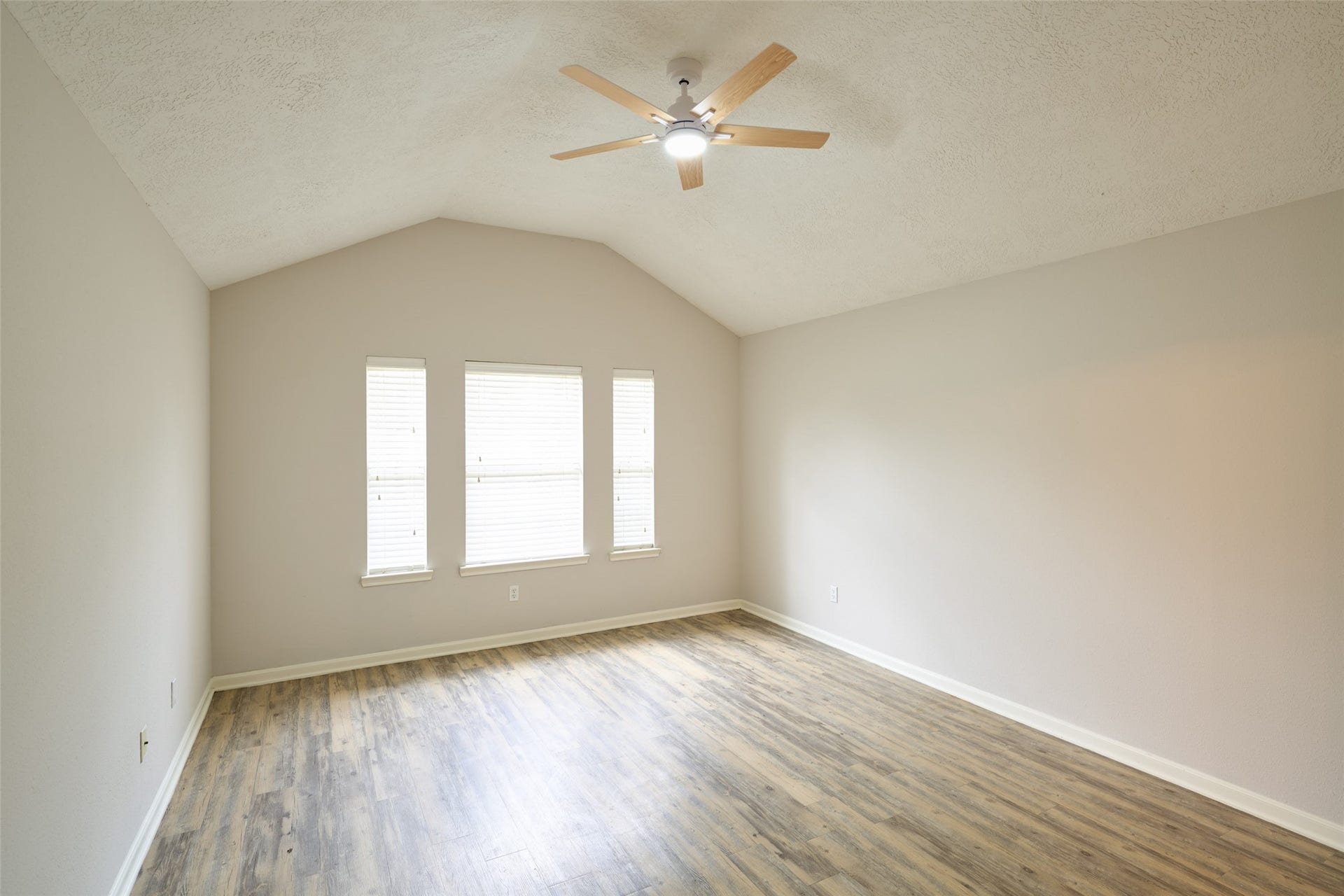 Primary bedroom with natural light and blinds for privacy.