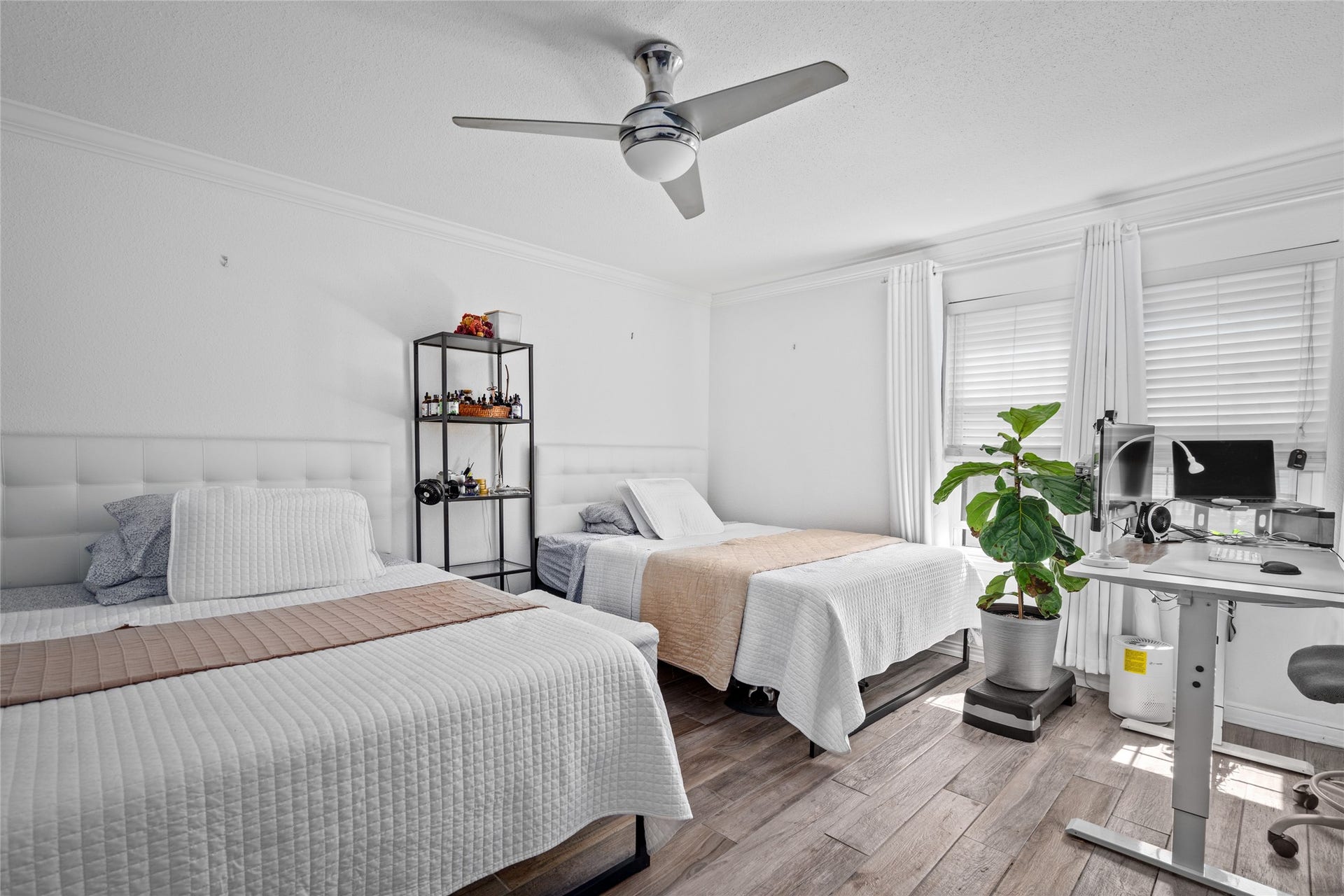 9850 Pagewood Lane, #1302, Houston, TX 77042 This well-lit secondary bedroom features ample space, large windows with elegant coverings, and a neutral color palette that enhances its bright and airy feel. The wood-look flooring adds warmth and style, while the ceiling fan provides comfort. A versatile layout makes this room ideal for various uses.