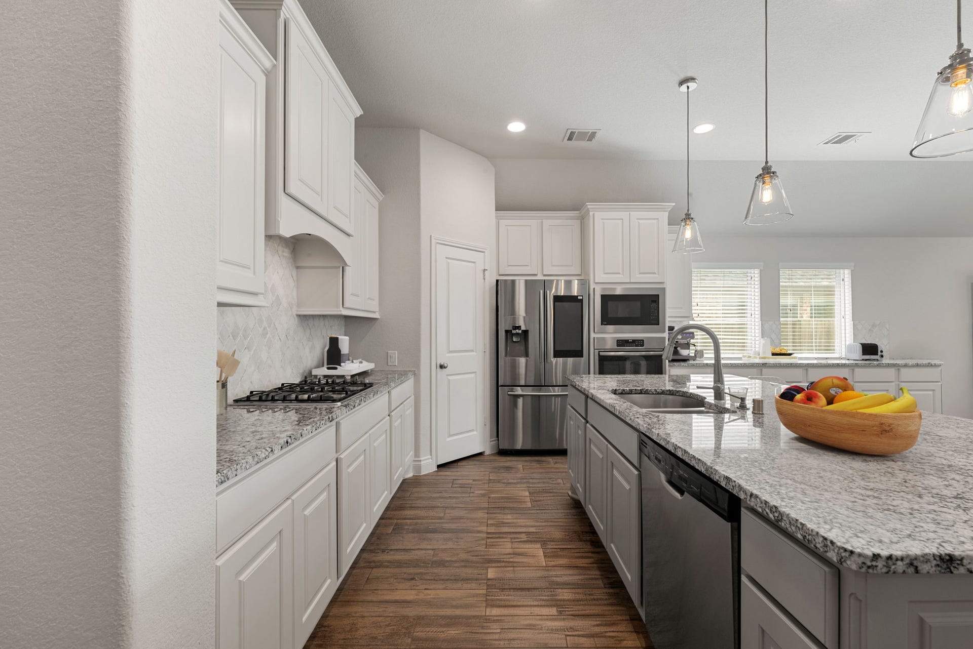 2419 Elmwood Trail, Katy, TX 77493 Bright and spacious kitchen with granite countertops, large island, white cabinetry, stainless steel appliances, pendant lighting, and plenty of storage. Functional layout perfect for cooking and entertaining.