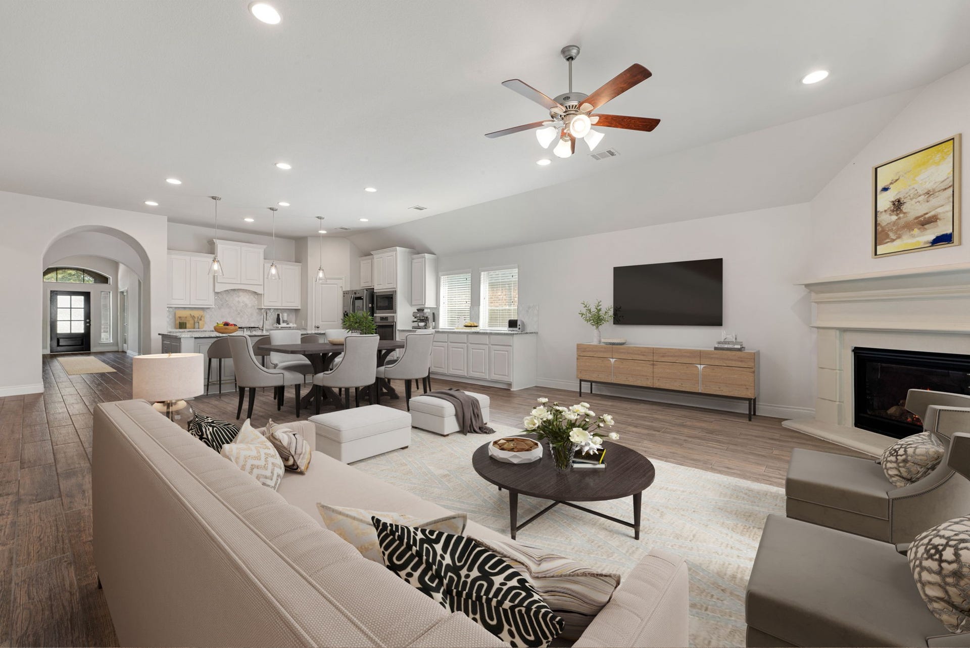 2419 Elmwood Trail, Katy, TX 77493 Open-concept living, dining, and kitchen area with high ceilings, recessed lighting, wood-look flooring, and a cozy fireplace. Bright and spacious layout perfect for everyday living and entertaining.