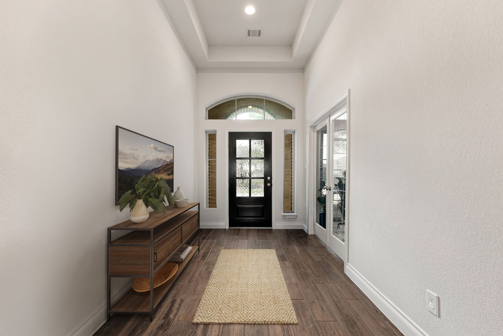 2419 Elmwood Trail, Katy, TX 77493 Grand entry foyer with high ceilings, tray ceiling detail, wood-look flooring, and an elegant front door with glass inserts. Bright and inviting space with natural light and a beautiful first impression.