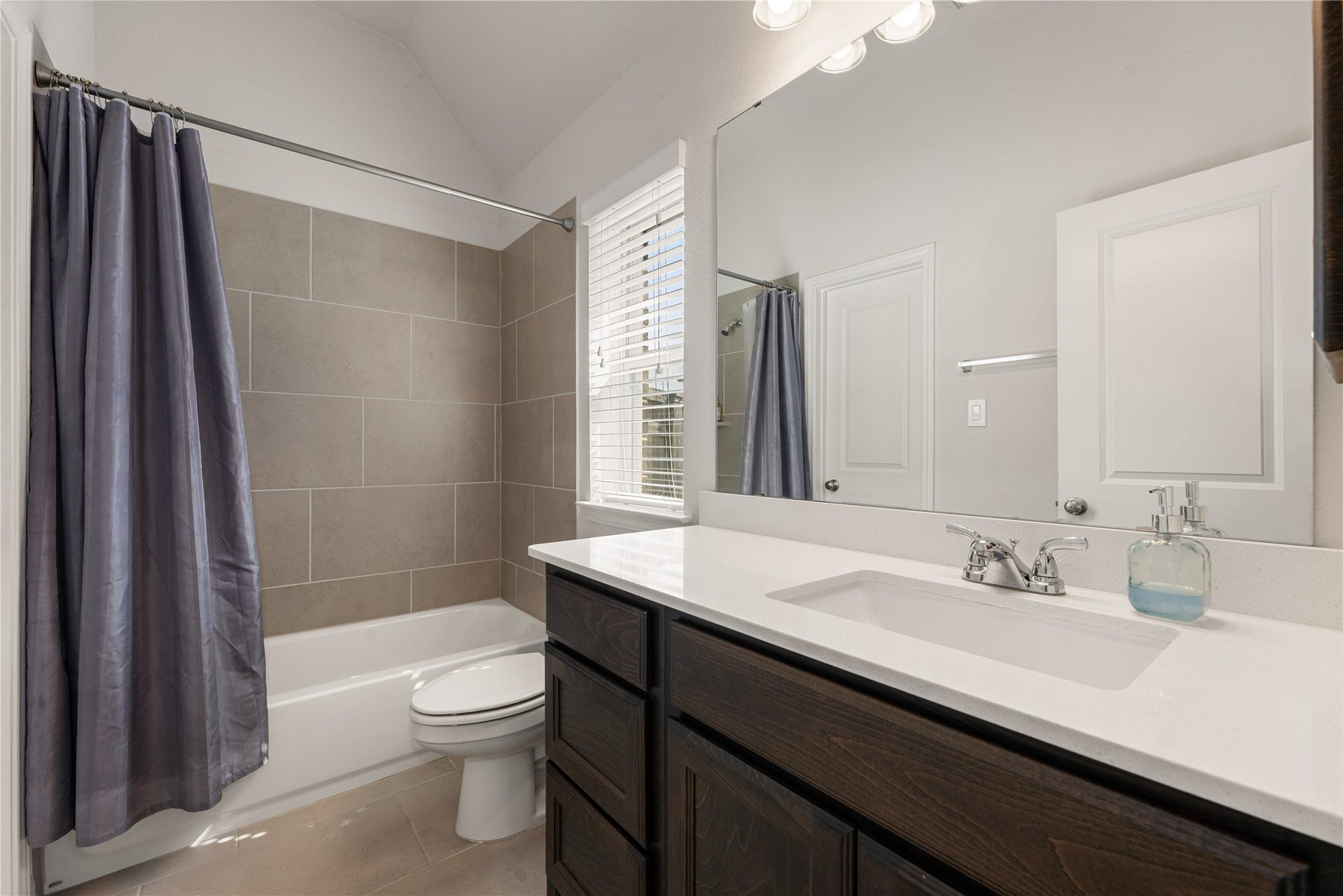 2419 Elmwood Trail, Katy, TX 77493 Secondary bathroom with modern vanity, tiled shower/tub combo, and plenty of natural light. Clean and functional space with neutral finishes.
