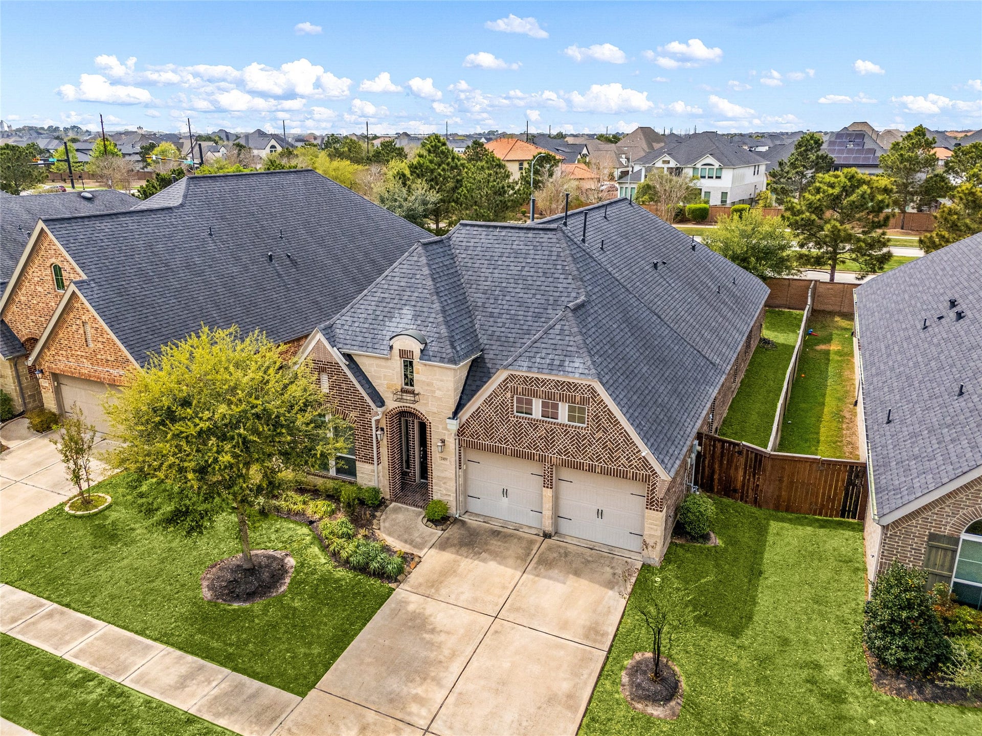 2419 Elmwood Trail, Katy, TX 77493 Beautiful brick and stone elevation with excellent curb appeal, featuring a well-maintained lawn, mature landscaping, and a double-wide driveway.
