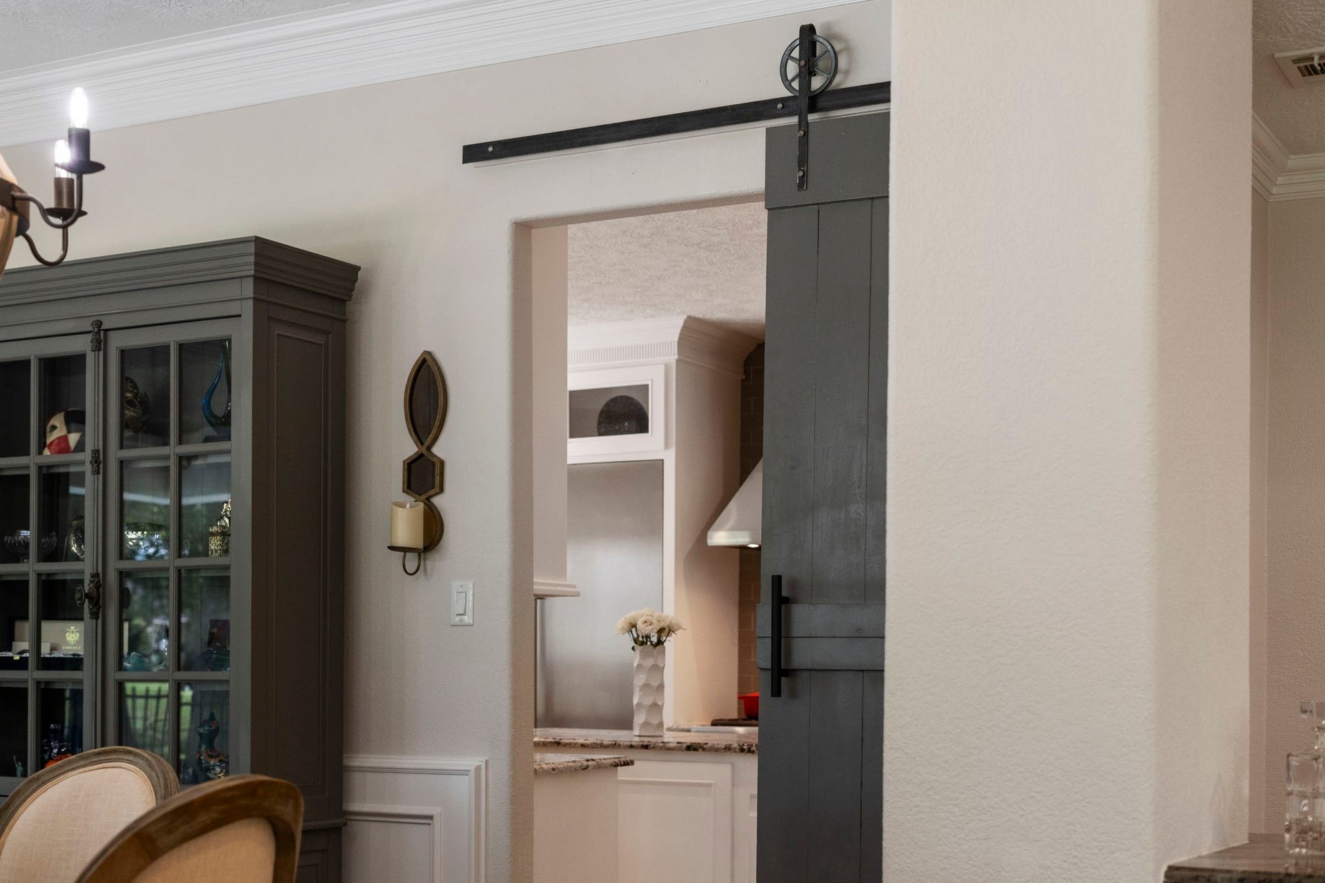 9 Charleston Street S, Sugar Land, TX 77478 A sliding barn door creates a distinctive architectural transition between the dining room and kitchen.