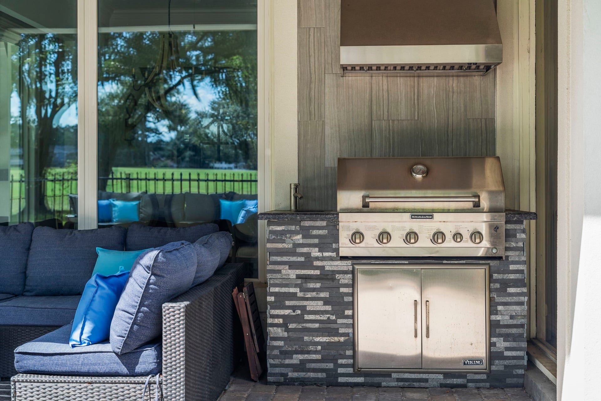 9 Charleston Street S, Sugar Land, TX 77478 A stainless steel gas grill is complemented by an overhead vent hood and convenient storage underneath, creating a functional setup for outdoor cooking and entertaining.