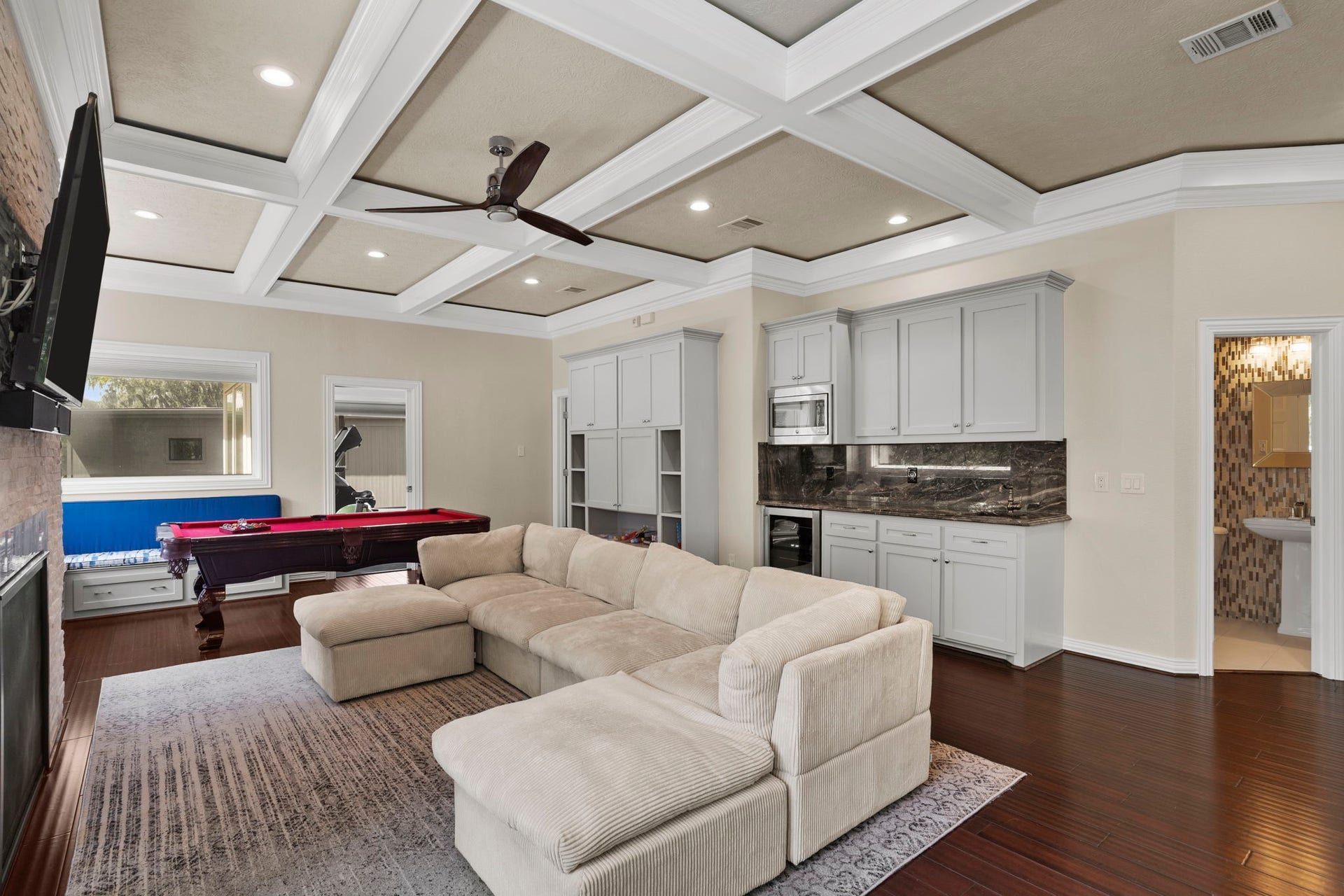 9 Charleston Street S, Sugar Land, TX 77478 A coffered ceiling, remote-start gas fireplace, and kitchenette make this an exceptional space for game days, gatherings, or relaxed evenings overlooking the course.
