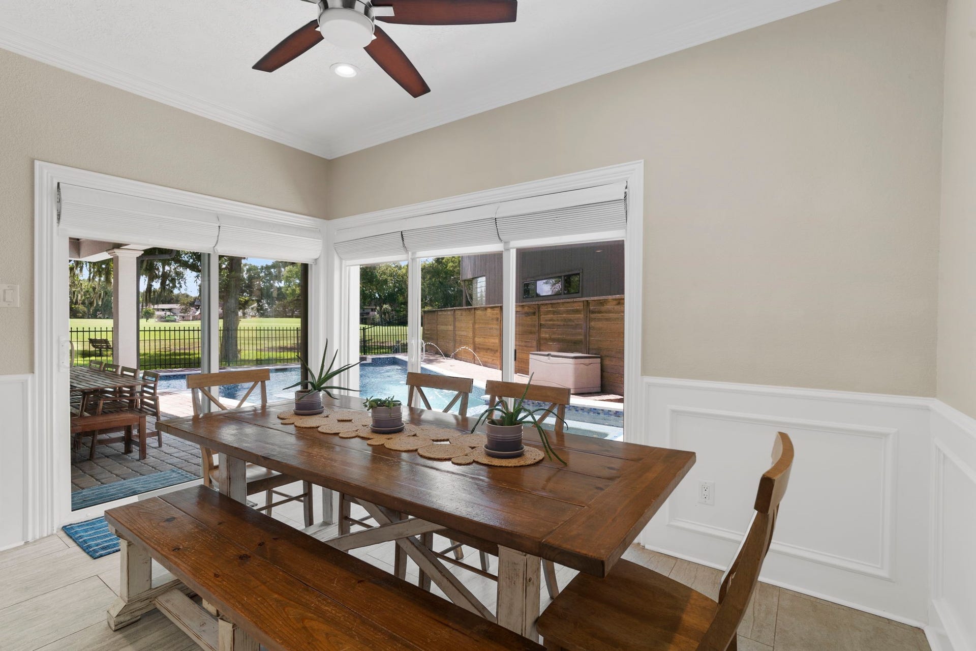9 Charleston Street S, Sugar Land, TX 77478 Glass sliding doors in the breakfast area open to the covered patio and pool, while expansive windows frame views of the pool and golf course beyond.