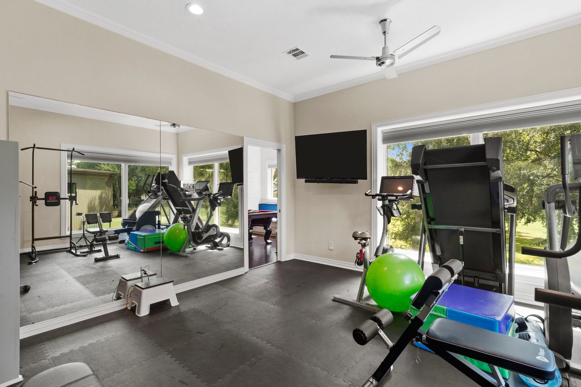 9 Charleston Street S, Sugar Land, TX 77478 Stay motivated in a bright, inviting exercise room featuring expansive windows with beautiful views of the golf course. A mounted TV adds entertainment while you work out.