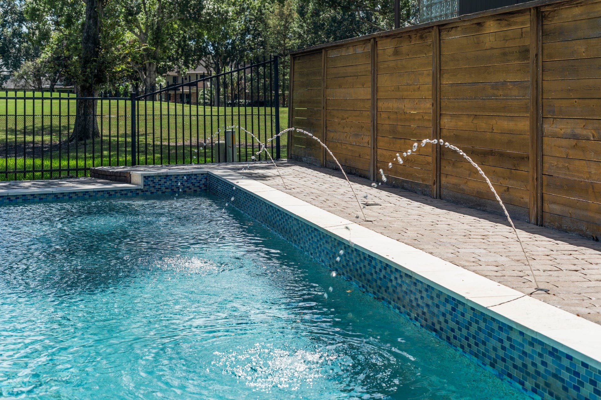 9 Charleston Street S, Sugar Land, TX 77478 Whimsical leaping deck jets add a playful touch to the pool, creating graceful arcs of water that dance along the pools edge and bring an extra sense of fun and movement to this inviting outdoor retreat.