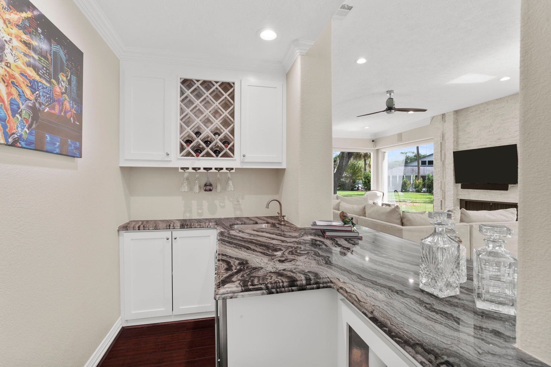 9 Charleston Street S, Sugar Land, TX 77478 An Italian Arabescato Orobico marble countertop anchors the sophisticated cocktail bar, complemented by a built-in wine rack, sink, beverage refrigerator, and ample storage.