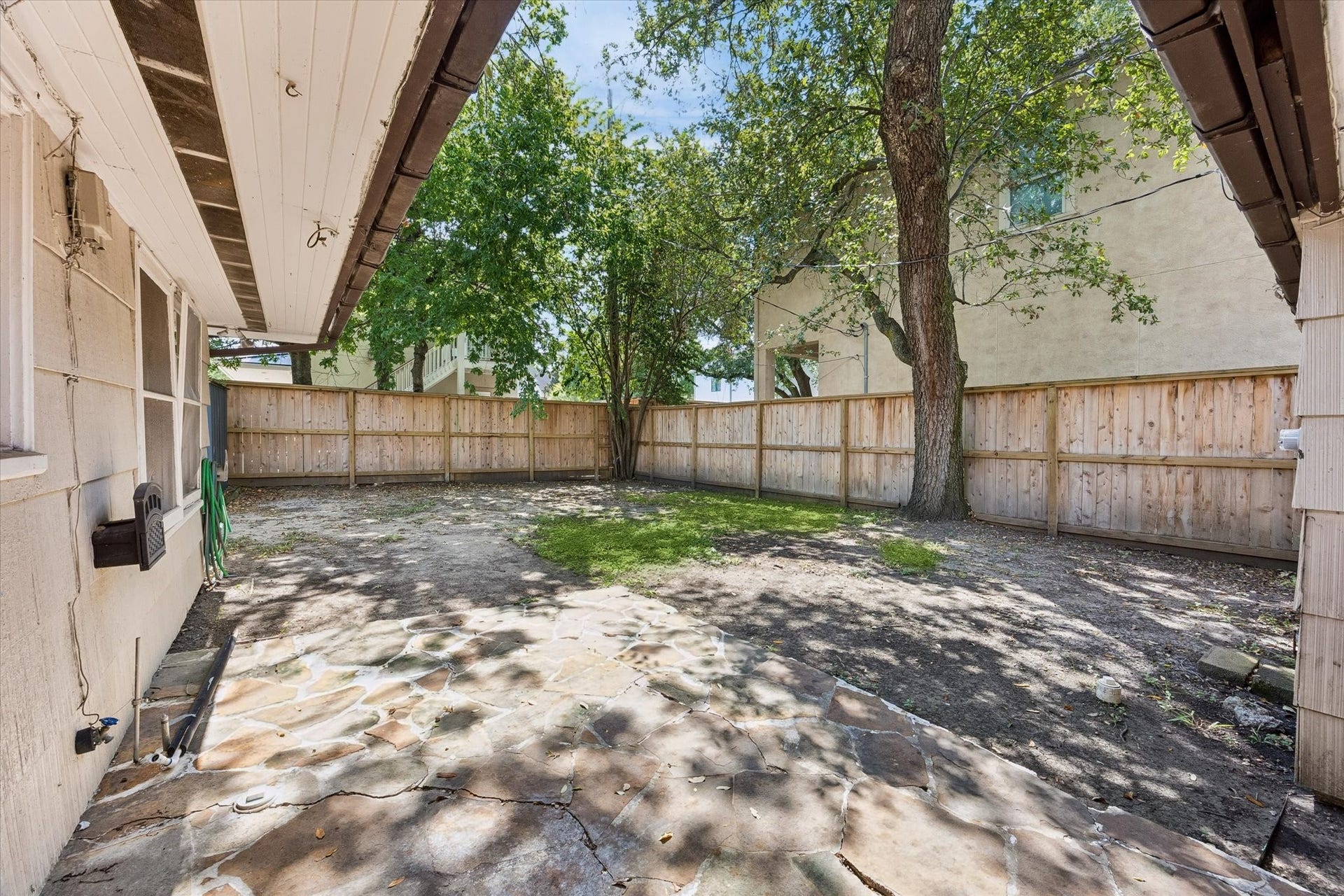 5119 PATRICK HENRY, Bellaire, TX 77401 Private backyard with stone patio, mature trees.