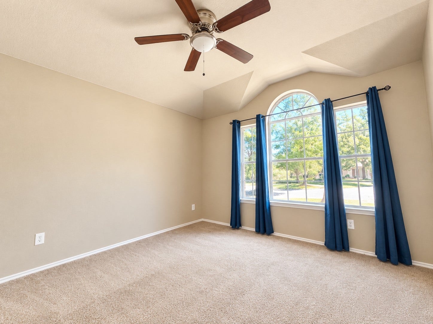 5007 Chase Mountain Drive, Bacliff, TX 77518 Spacious second bedroom featuring vaulted ceilings, a ceiling fan, and beautiful arched windows that fill the room with natural light. New carpet.