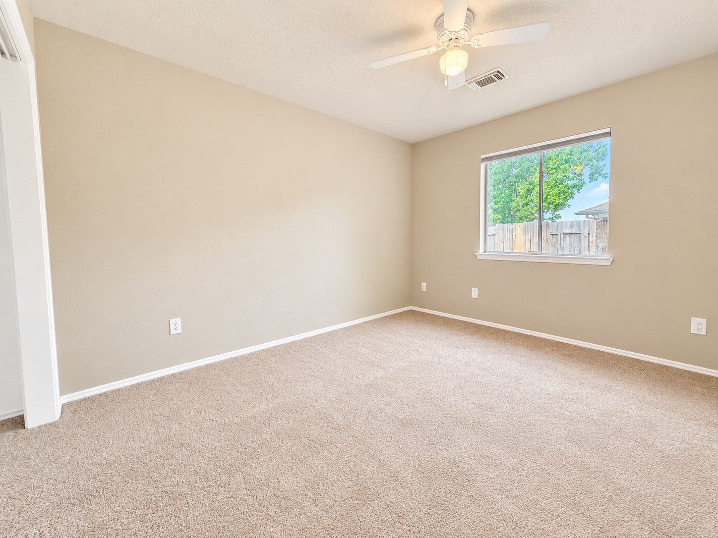 5007 Chase Mountain Drive, Bacliff, TX 77518 Third bedroom featuring neutral tones, soft carpeting, a ceiling fan, and a large window overlooking the backyard. New carpet.