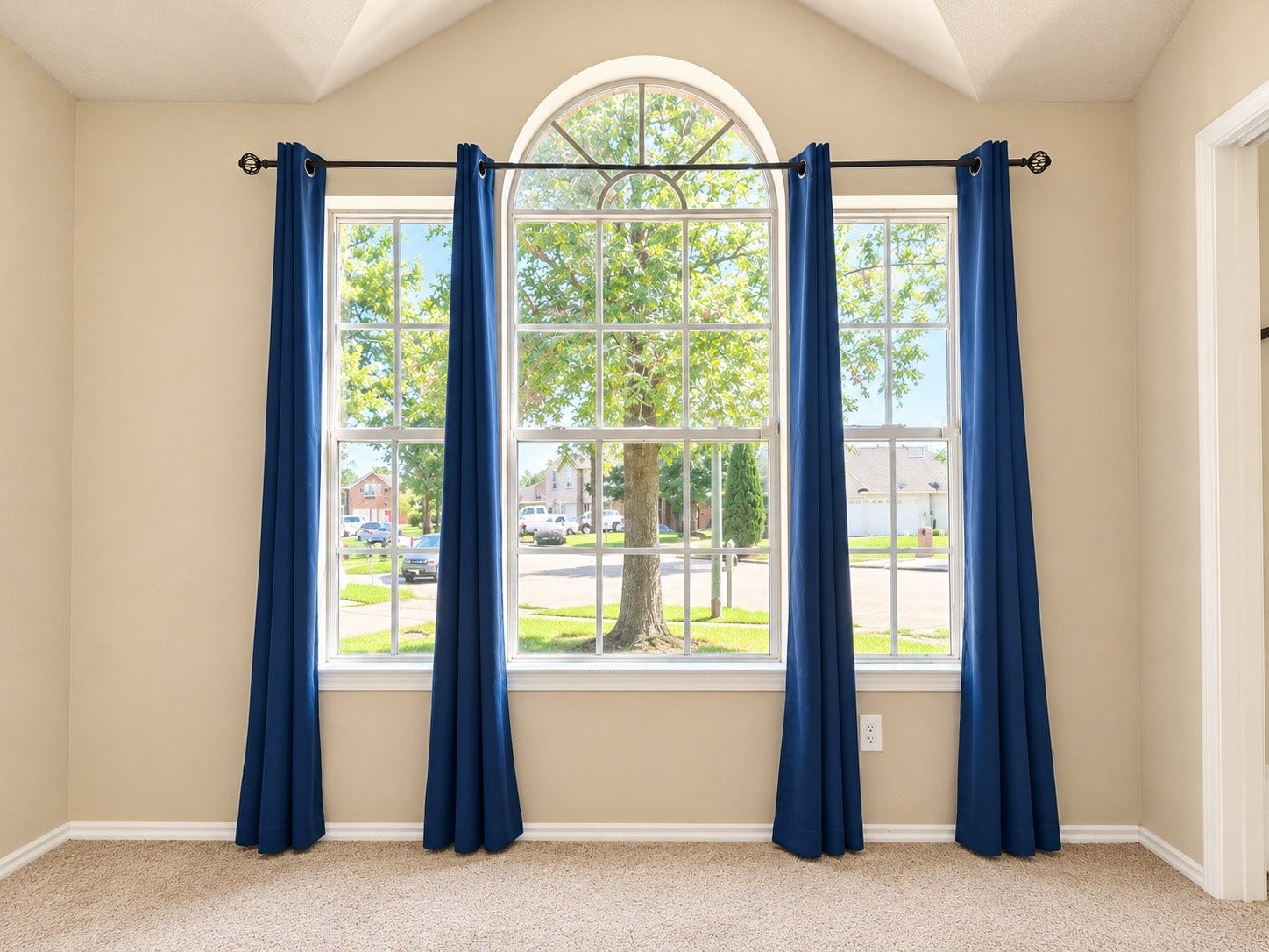 5007 Chase Mountain Drive, Bacliff, TX 77518 Second bedroom features a beautiful arched window, abundant natural light, and views of the tree-lined neighborhood.