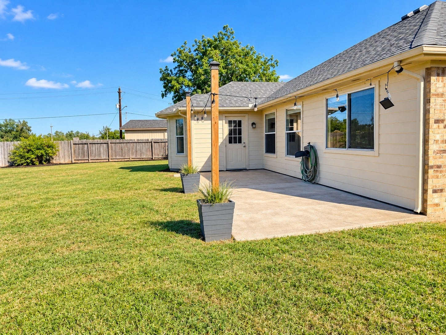 5007 Chase Mountain Drive, Bacliff, TX 77518 Backdoor leads to a cement patio area with hanging lighting.