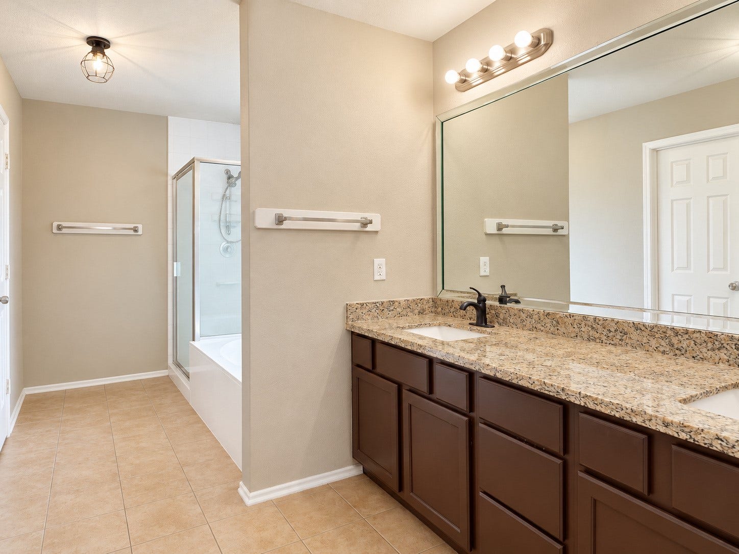 5007 Chase Mountain Drive, Bacliff, TX 77518 Primary on-suite bathroom with two sink vanity and granite counter top that matches the kitchen and second bath countertops.