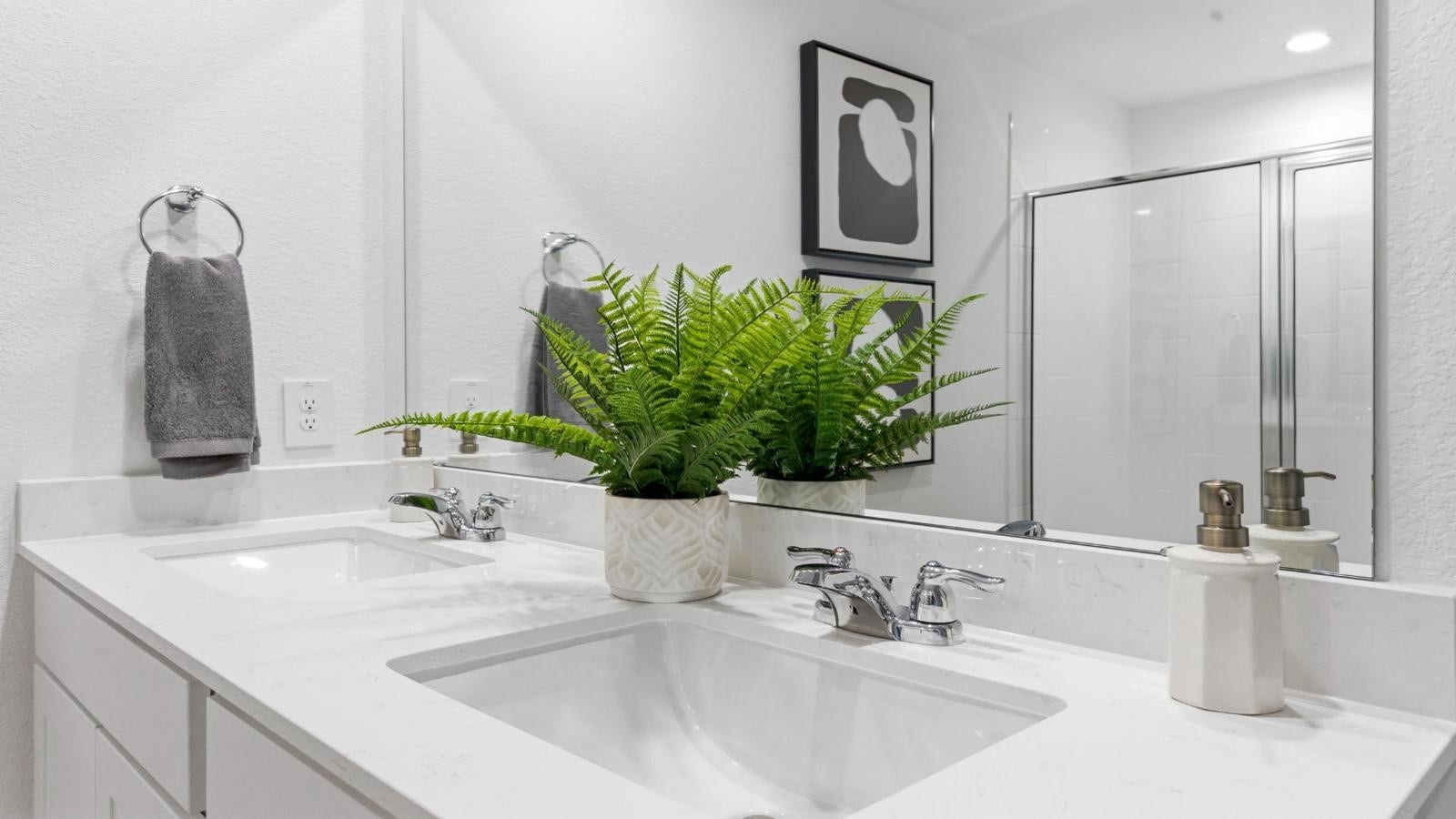 14223 Starboard Reach Drive, Texas City, TX 77510 Modern primary bathroom with double vanities, quartz countertops, and a glass-enclosed shower with a walk-in closet.