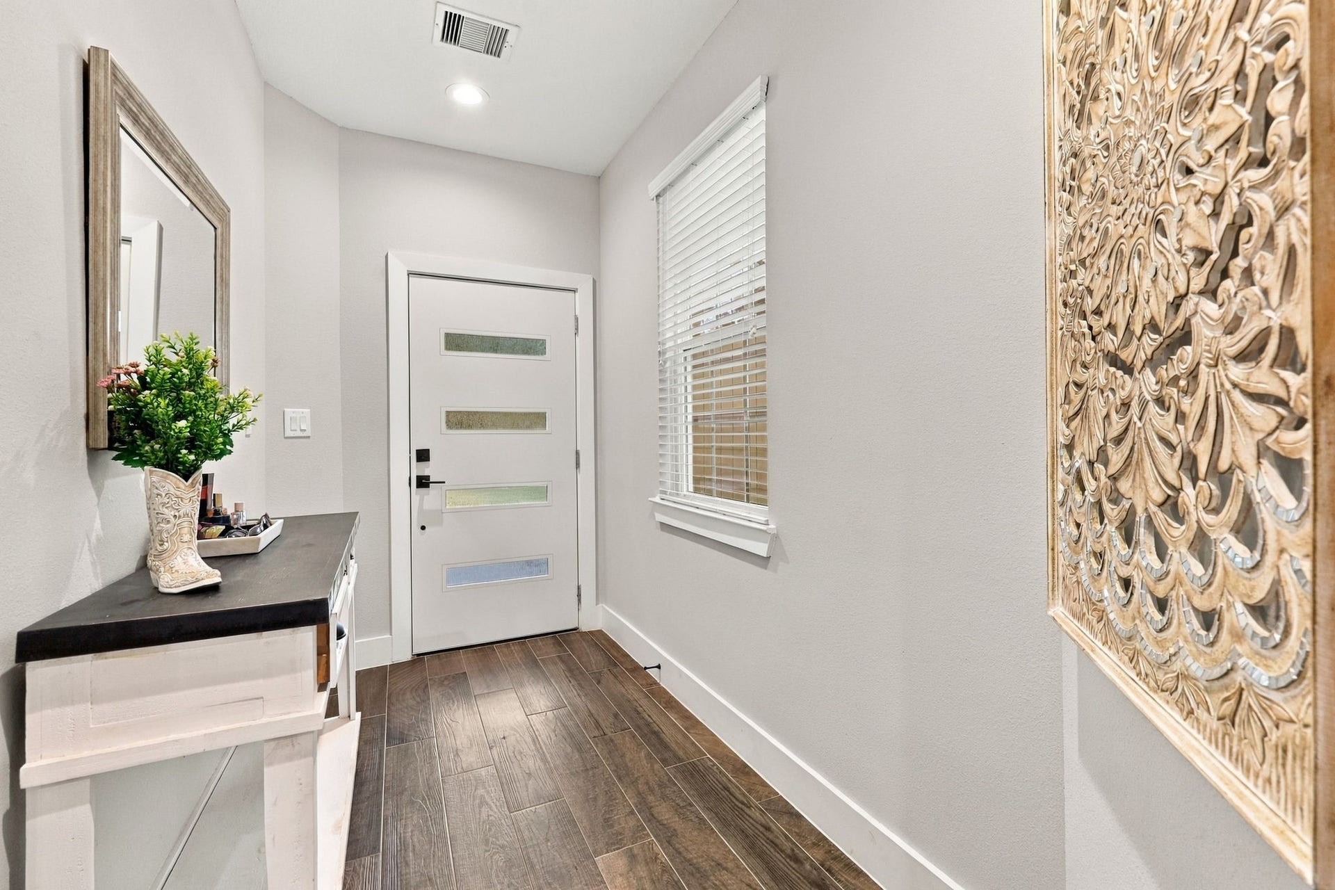 1116 Bennington Street, Houston, TX 77022 Welcoming foyer with modern front door, wood-look flooring and a bright, open feel.