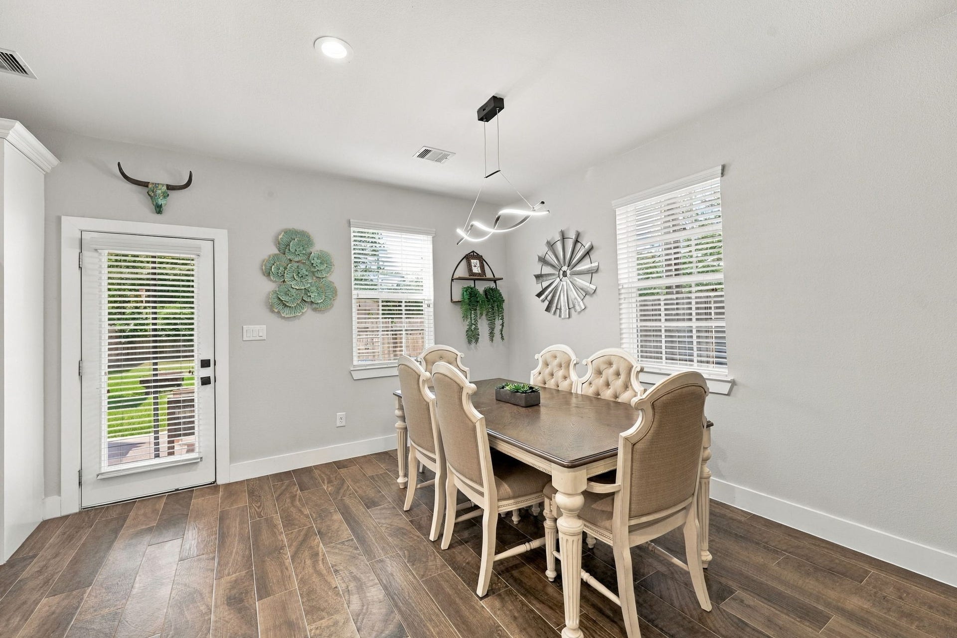 1116 Bennington Street, Houston, TX 77022 Elegant dining area with a modern light fixture, abundant natural light and glass door leading to the outdoor living space.