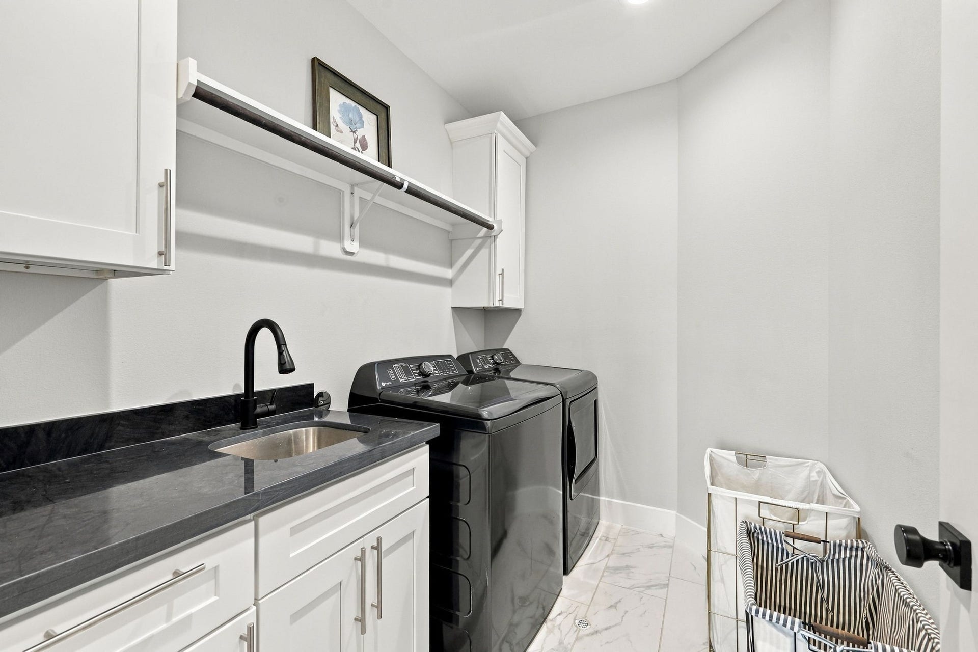 1116 Bennington Street, Houston, TX 77022 Laundry room thoughtfully located on the second floor features utility sink, countertop space, hanging rod and convenient cabinetry for storage.