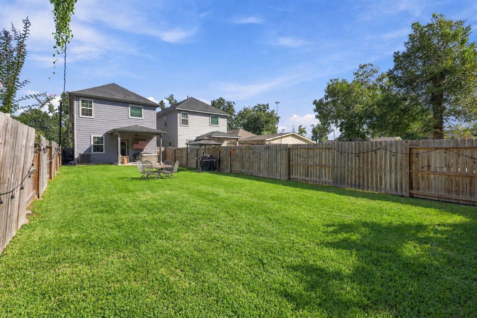 1116 Bennington Street, Houston, TX 77022 Rear elevation showcasing modern design and private outdoor living, with a fully fenced yard offering room for pets, play or gardening.