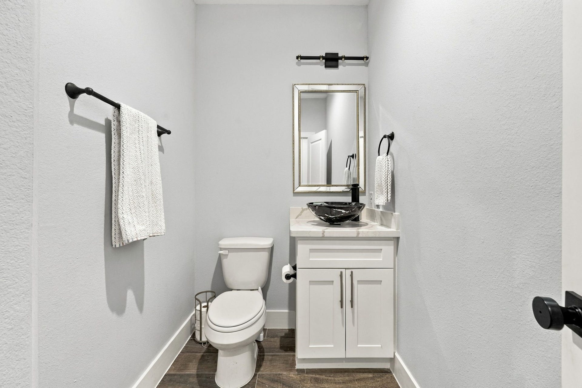 1116 Bennington Street, Houston, TX 77022 Modern powder room featuring contemporary fixtures, a vessel sink and elegant cabinetry.