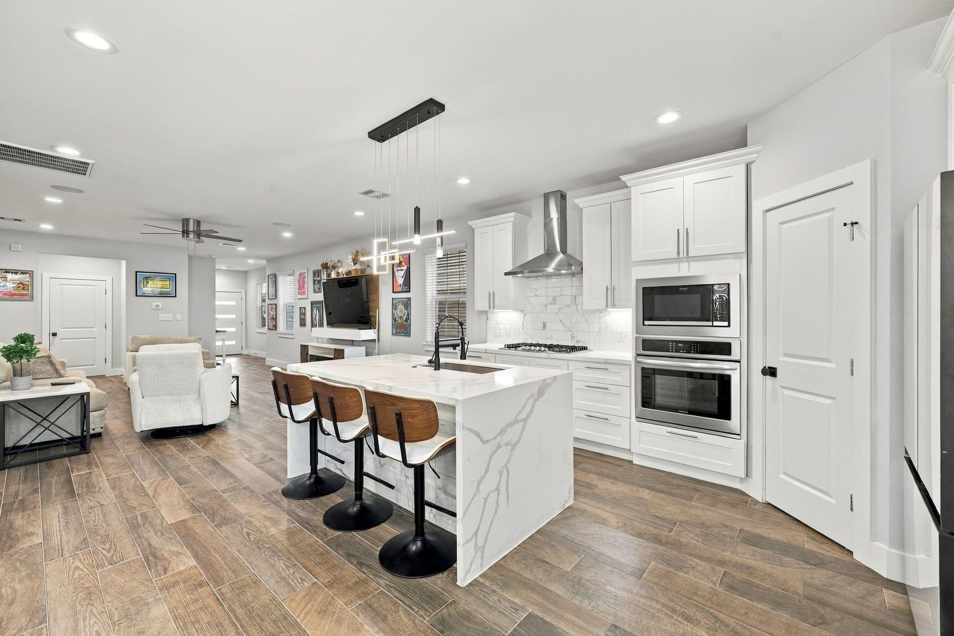 1116 Bennington Street, Houston, TX 77022 Another view of the kitchen featuring soft-close cabinets and drawers, stainless steel appliances and a large center island with seating.