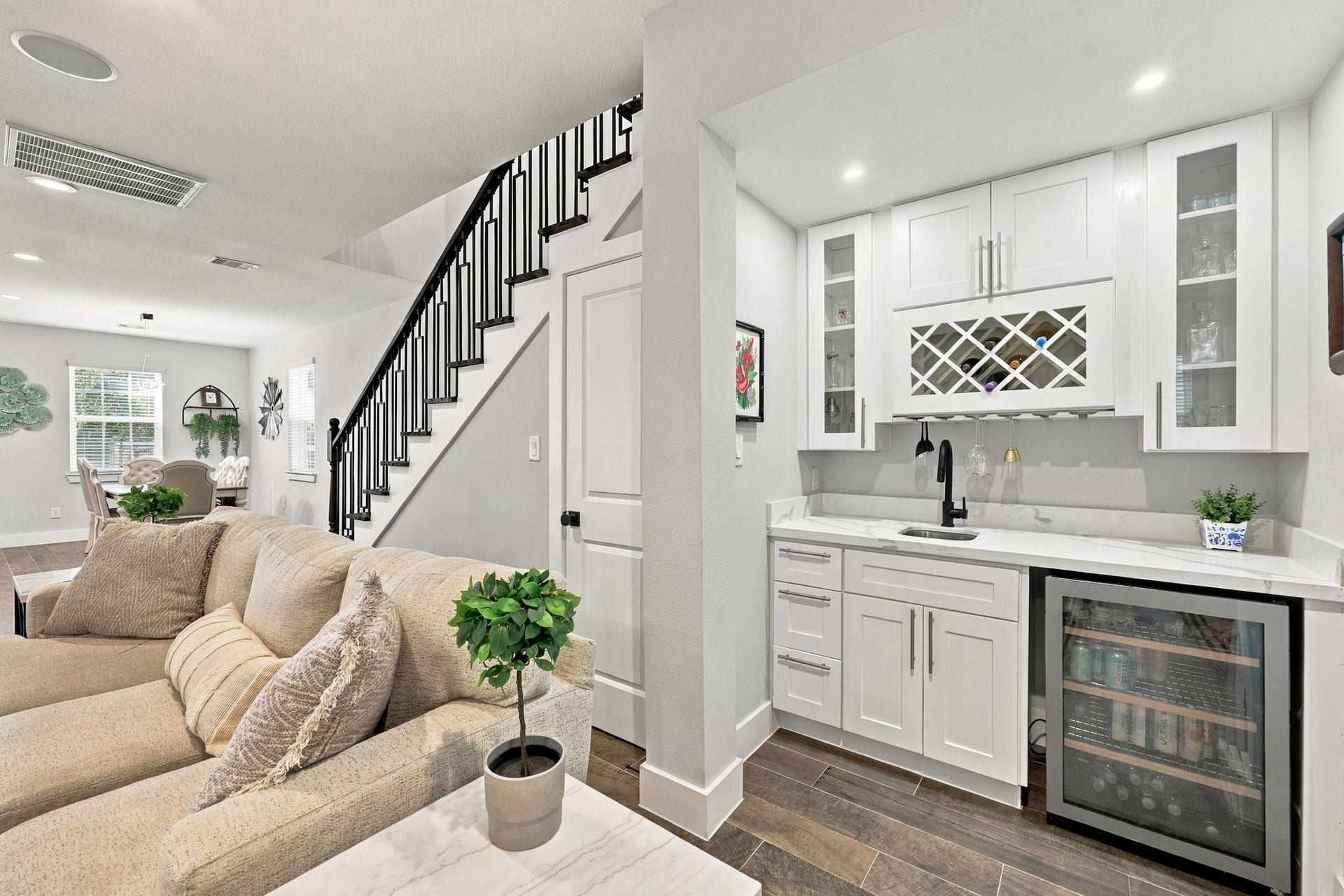 1116 Bennington Street, Houston, TX 77022 Wet bar featuring wine storage, glass-front cabinetry, sink and beverage refrigerator is ideal for entertaining.