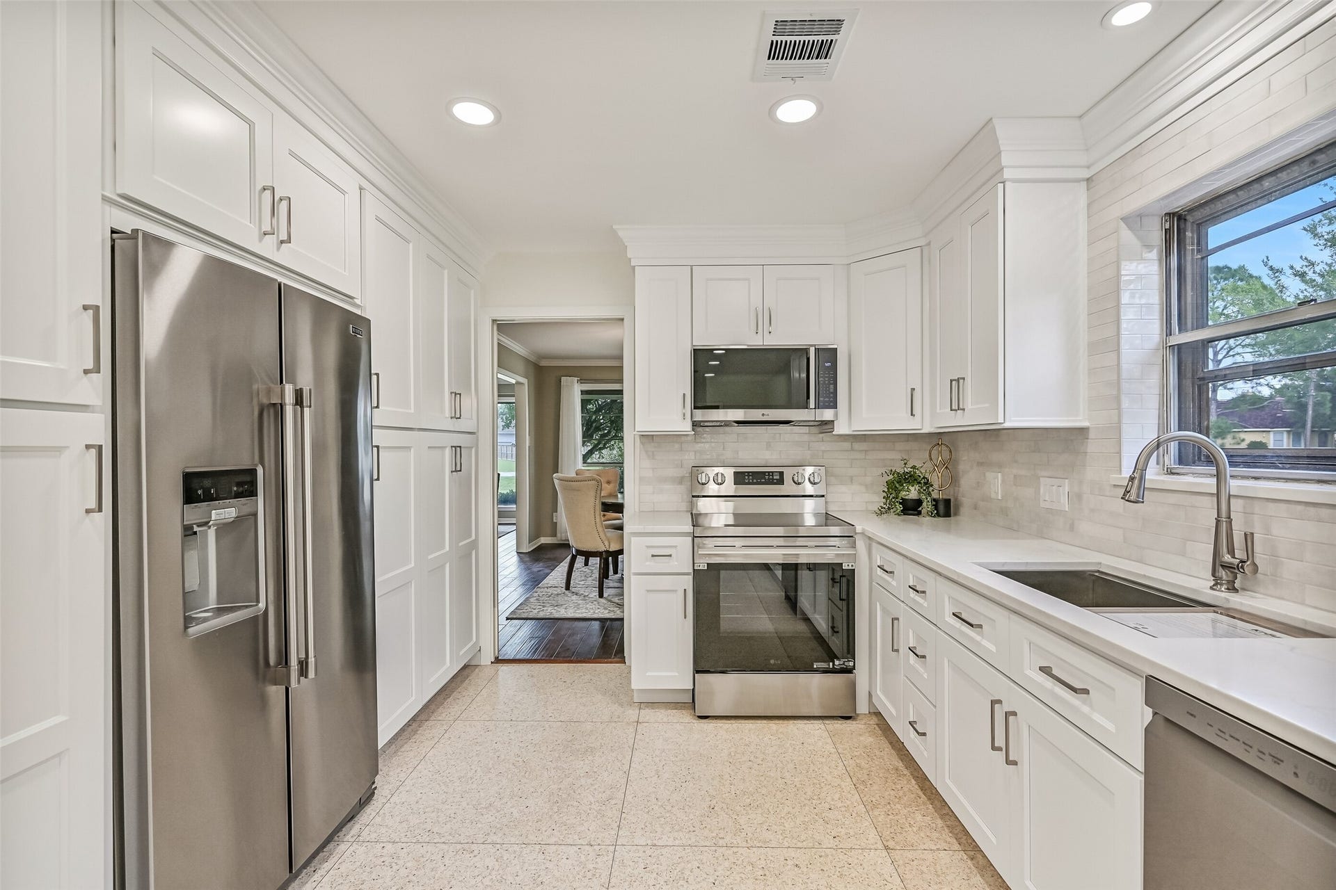 304 Chester Drive, Friendswood, TX 77546 Kitchen First Residence:
The kitchen offers generous storage and prep space highlighted by extensive cabinetry, quartz countertops, and a functional layout with a smooth glass cooktop & oven, a vent hood microwave, and a dual basin undermount sink with a goosneck faucet.