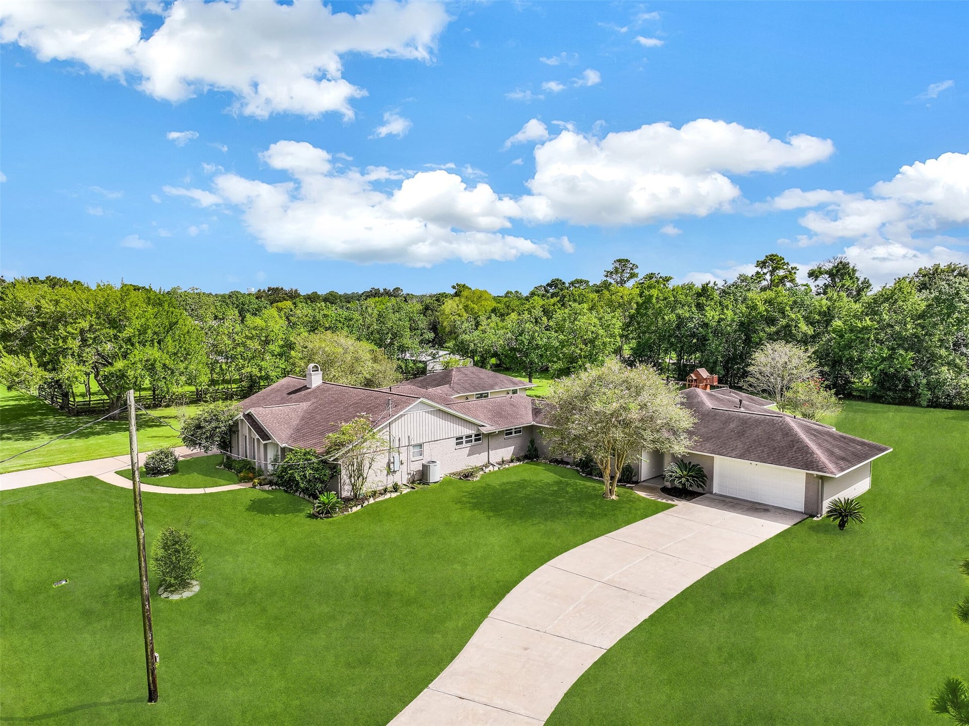 304 Chester Drive, Friendswood, TX 77546 Aerial View of Second Residence Side:
The second residence boasts a classic painted brick exterior with a covered entry, manicured landscaping, a long private driveway, & a 2-car attached garage, all positioned on a spacious 1.3-acre lot.