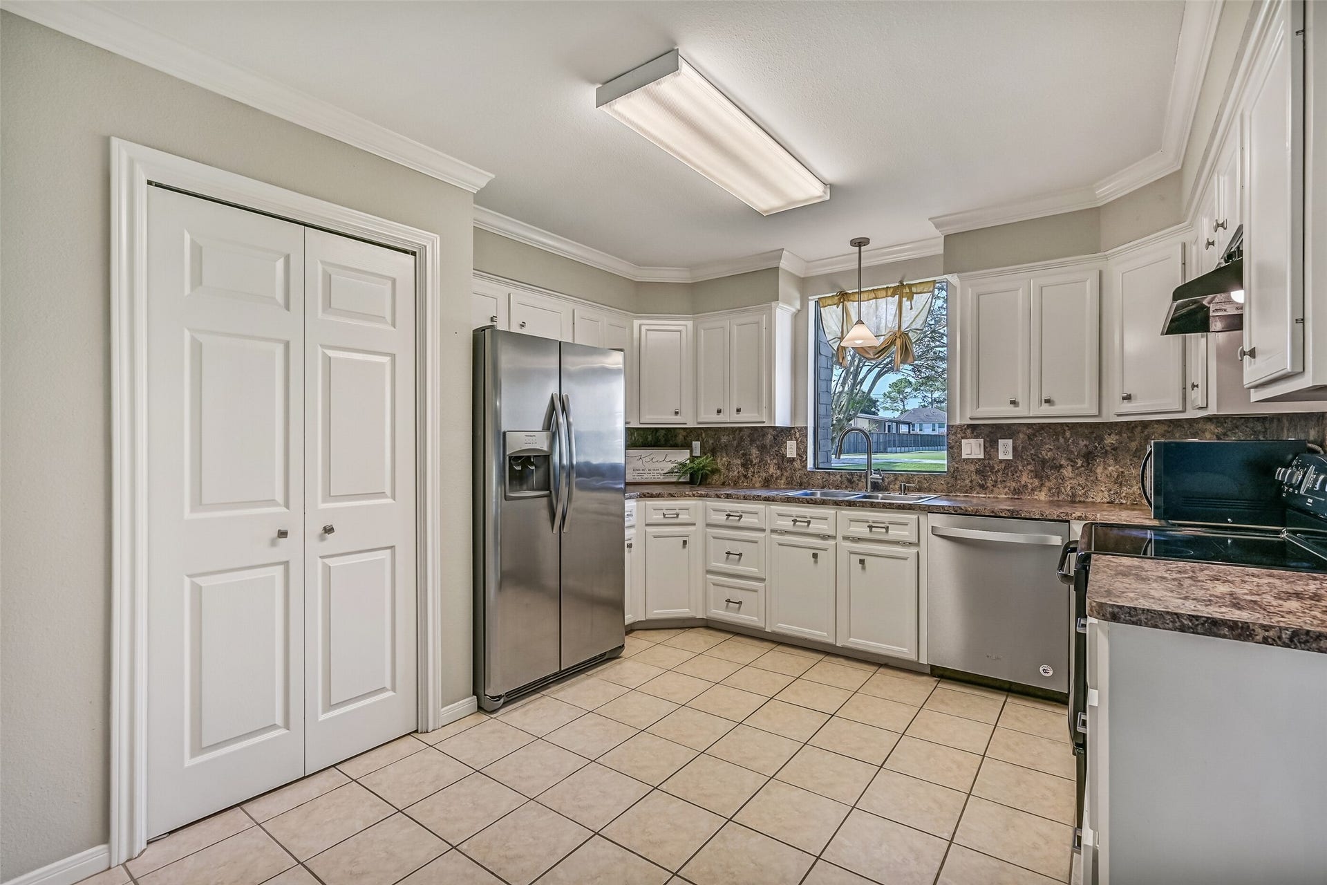 304 Chester Drive, Friendswood, TX 77546 Kitchen Second Residence:
The bright & functional kitchen boasts abundant cabinetry, generous granite-look countertops, and a full appliance package that includes a smooth glass cooktop. A window over the sink brings in natural light and views of the front yard.