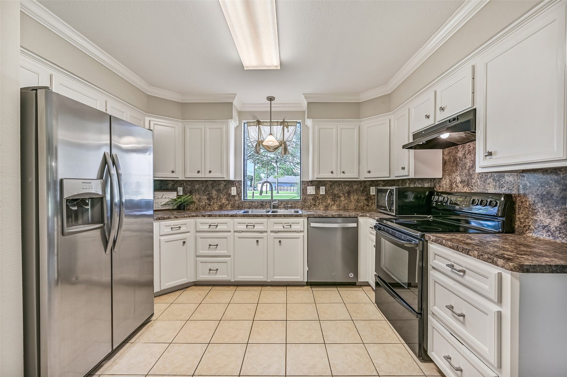 304 Chester Drive, Friendswood, TX 77546 Kitchen Second Residence:
The bright & functional kitchen boasts abundant cabinetry, generous granite-look countertops, and a full appliance package that includes a smooth glass cooktop. A window over the sink brings in natural light and views of the front yard.