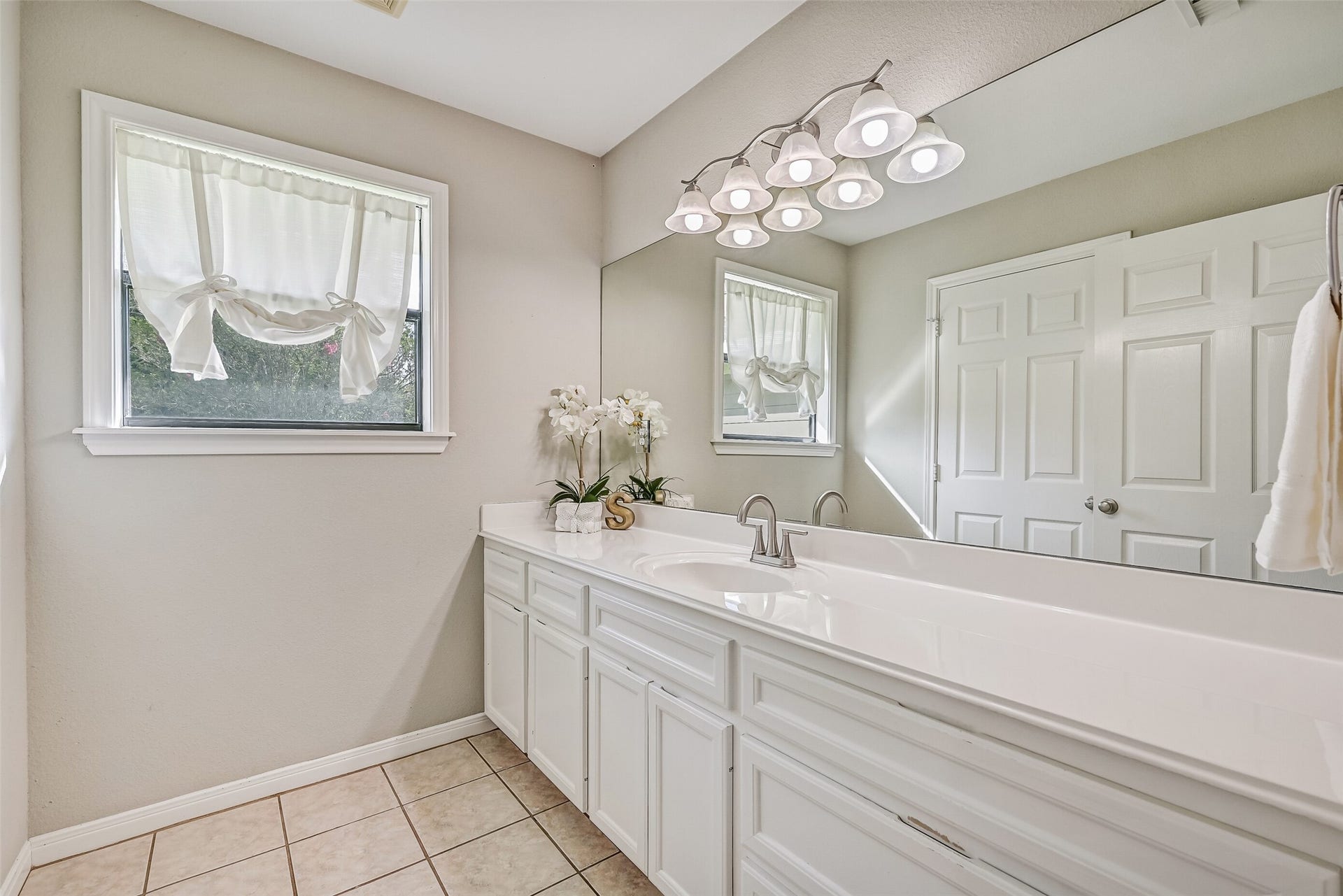 304 Chester Drive, Friendswood, TX 77546 Guest Bathroom Second Residence:
The guest bath offers an extended cultured marble vanity with ample storage, a wide mirror, and bright overhead lighting. The tub/shower combination offers easy access, while neutral finishes, tile flooring, and a window providing natural light create a clean, comfortable space.