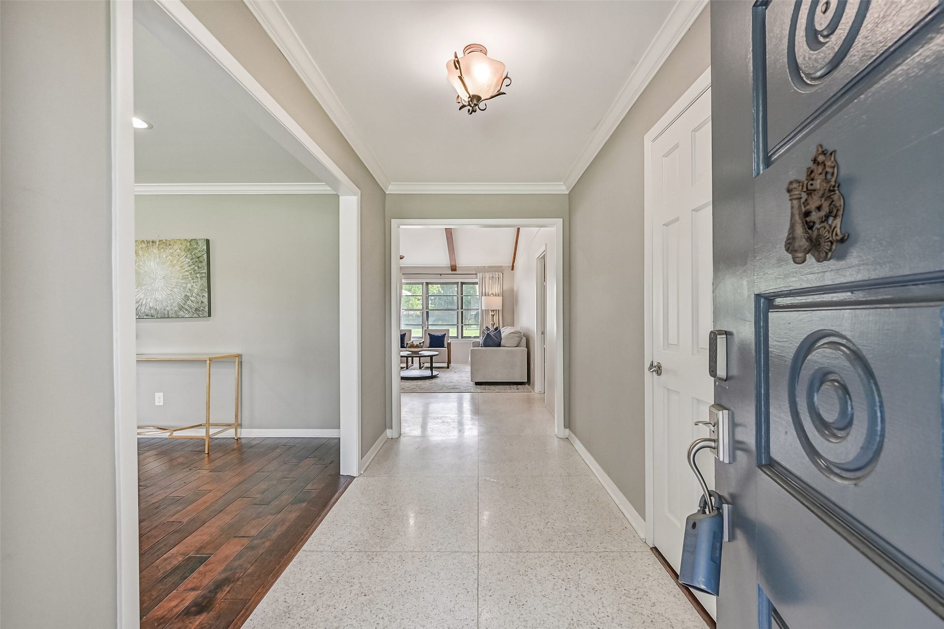 304 Chester Drive, Friendswood, TX 77546 Foyer First Residence:
Step through the inviting entry of the first home to experience clean sightlines into the light and bright living areas, finished with crown molding and a blend of terrazzo tile and wood flooring.
