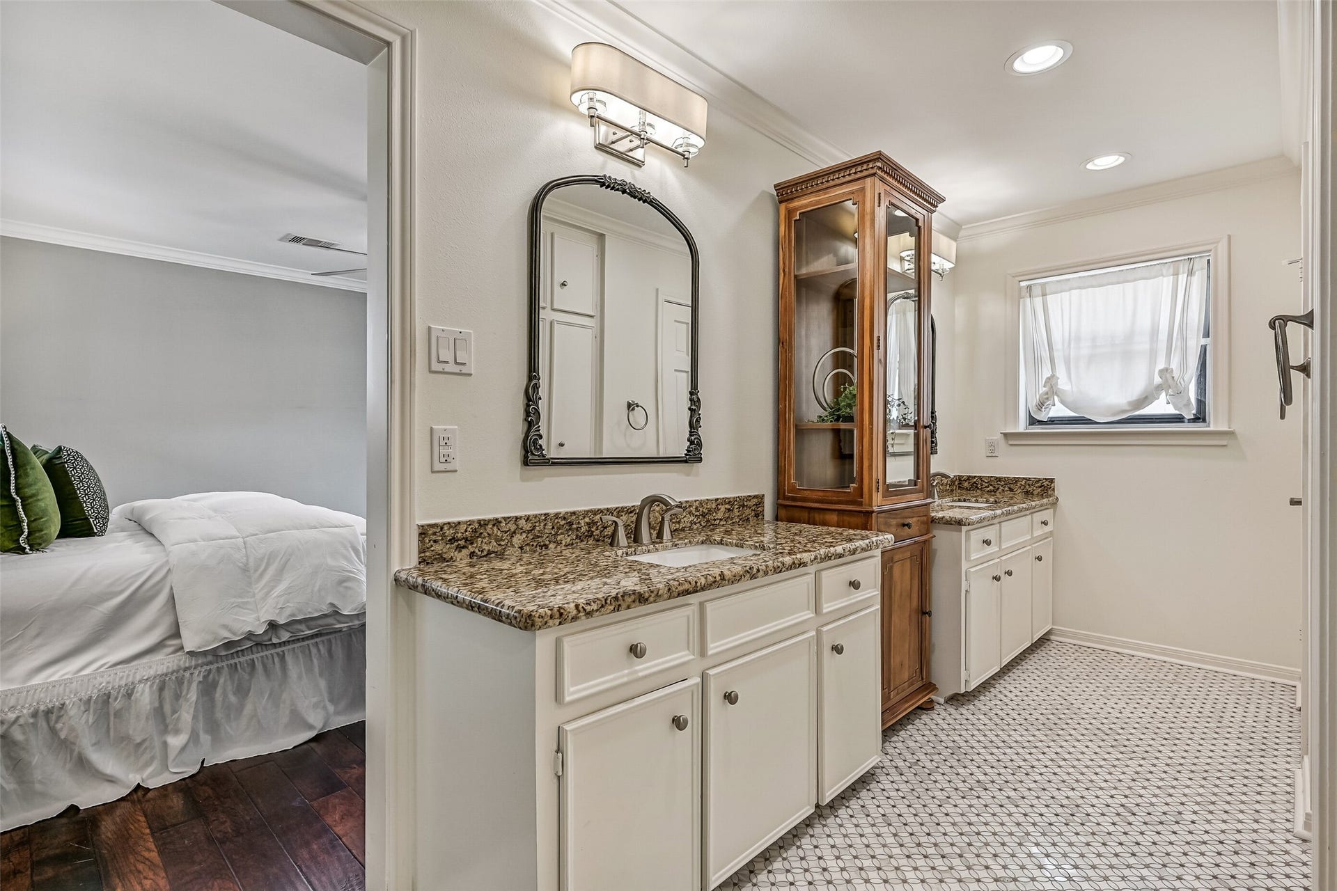 304 Chester Drive, Friendswood, TX 77546 Master Bathroom First Residence:
The master bath boasts dual vanities with granite countertops, abundant cabinetry, separated by a tower style storage cabinet. Recessed lighting, classic tile flooring, and a window providing natural light create a bright, functional, and roomy layout.